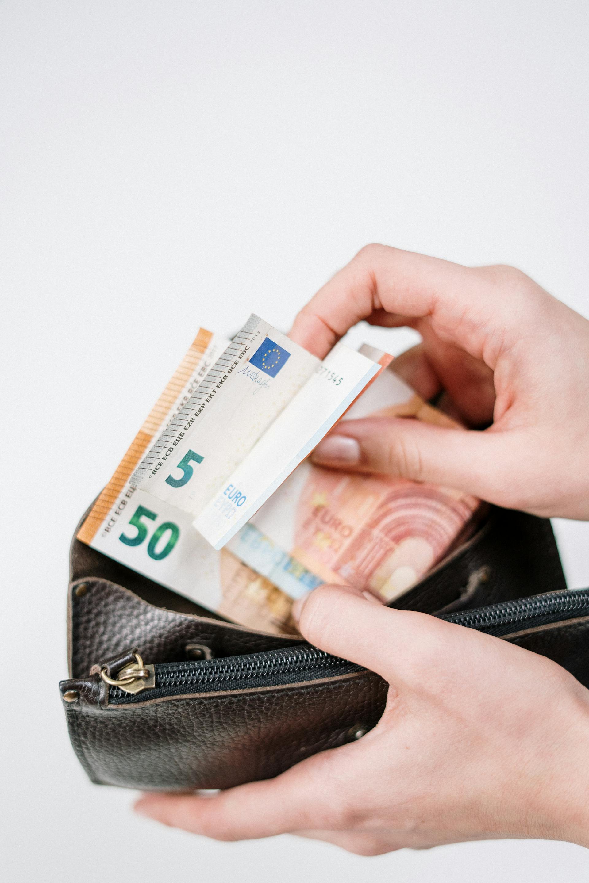 Une personne prenant de l'argent dans son portefeuille | Source : Pexels