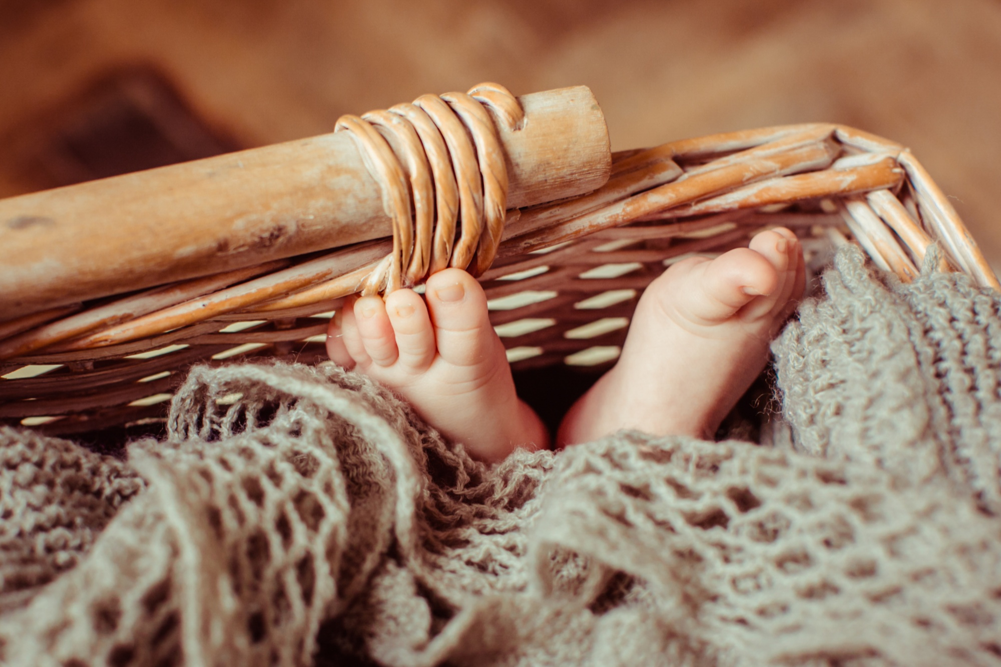 Les pieds d'un bébé couché dans un panier | Source : Freepik
