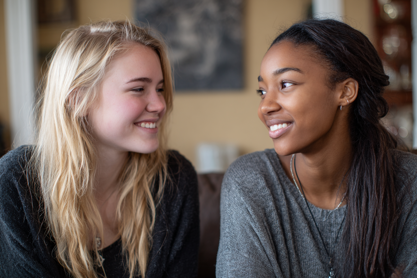 Deux adolescentes se sourient l'une à l'autre | Source : Midjourney
