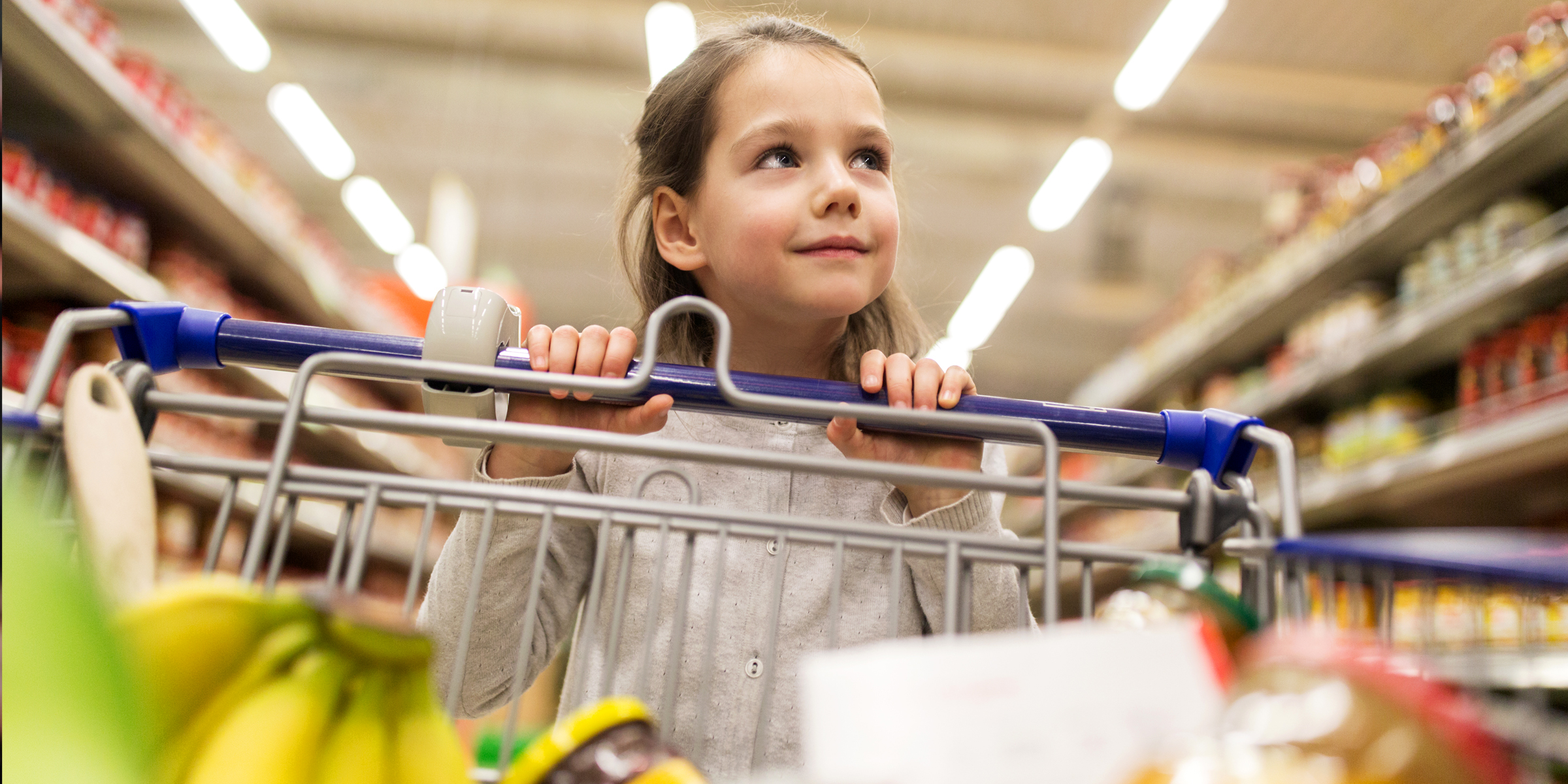 Une petite fille poussant un chariot de supermarché | Source : Shutterstock