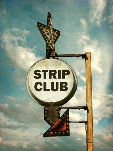 Une enseigne de club de strip-tease usée. | Photo : Shutterstock