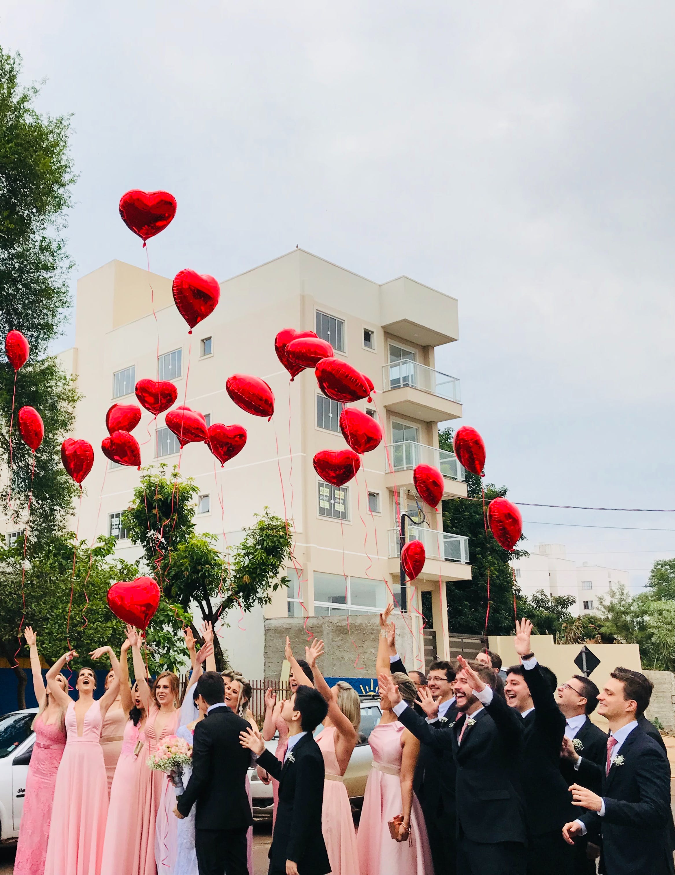 Une fête de mariage avec des ballons en forme de cœur lâchés dans la rue | Source : Pexels