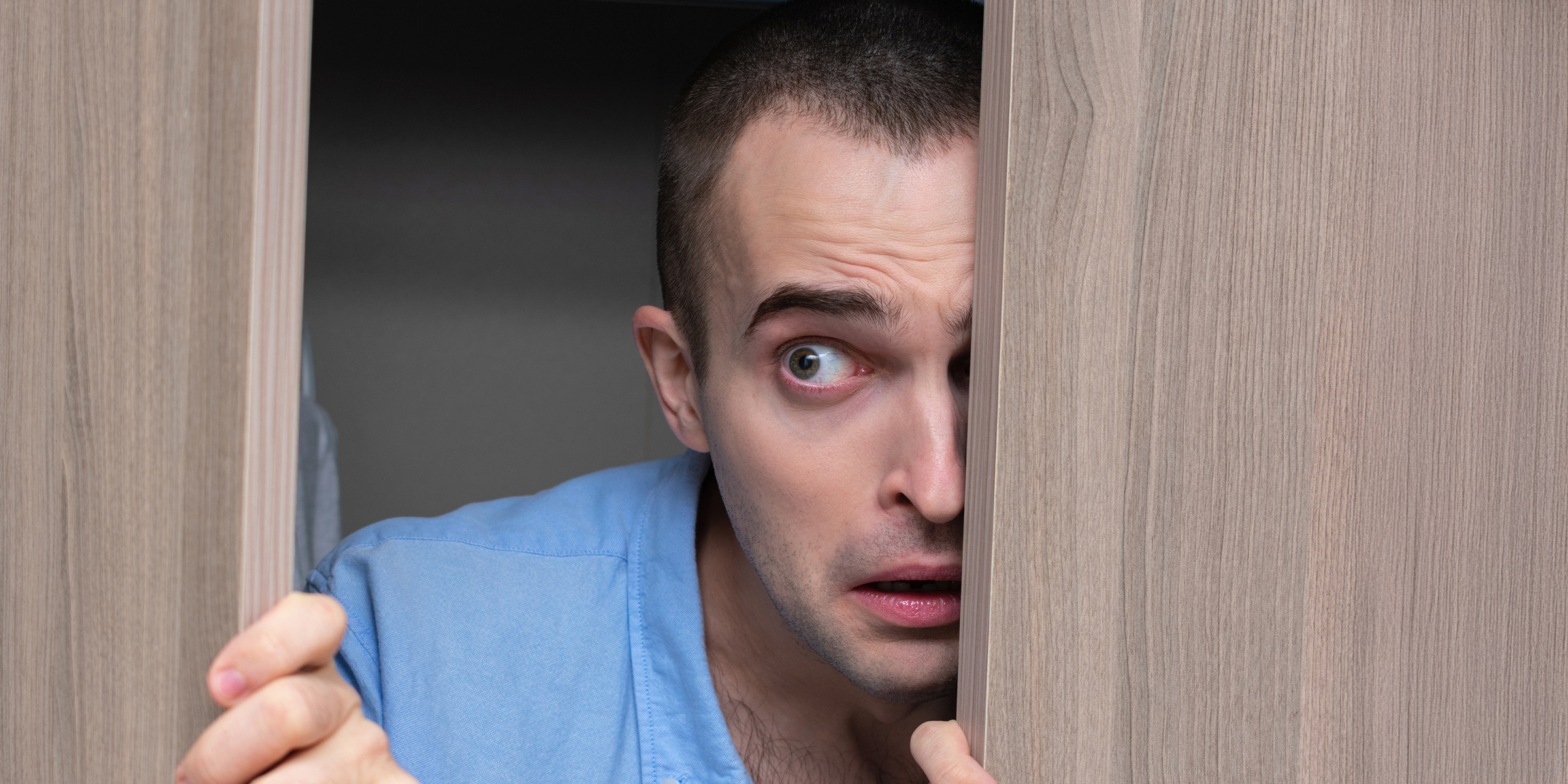 Un homme qui espionne à travers une porte | Source : Shutterstock