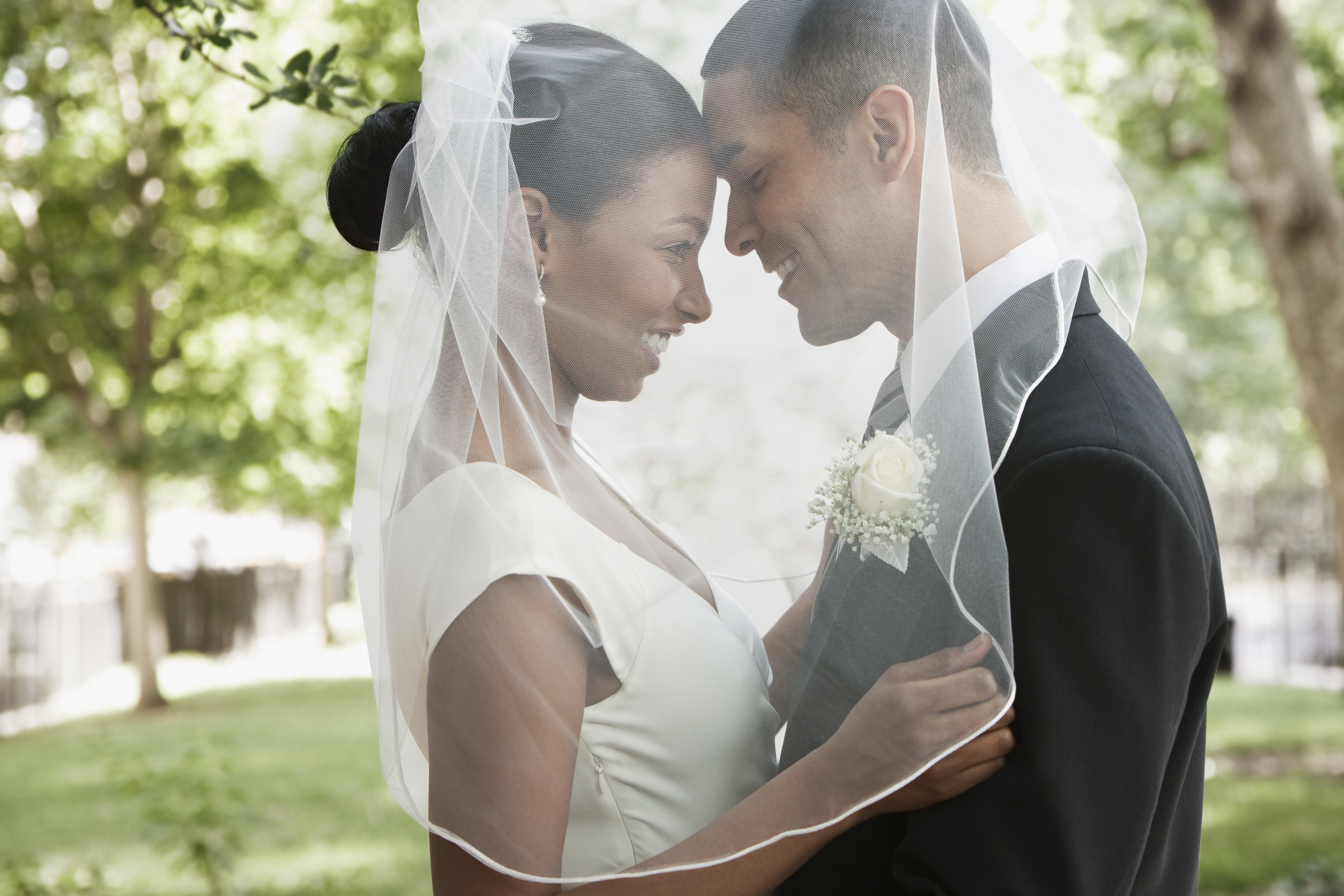 La mariée et le marié s'étreignent sous le voile | Source : Getty Images