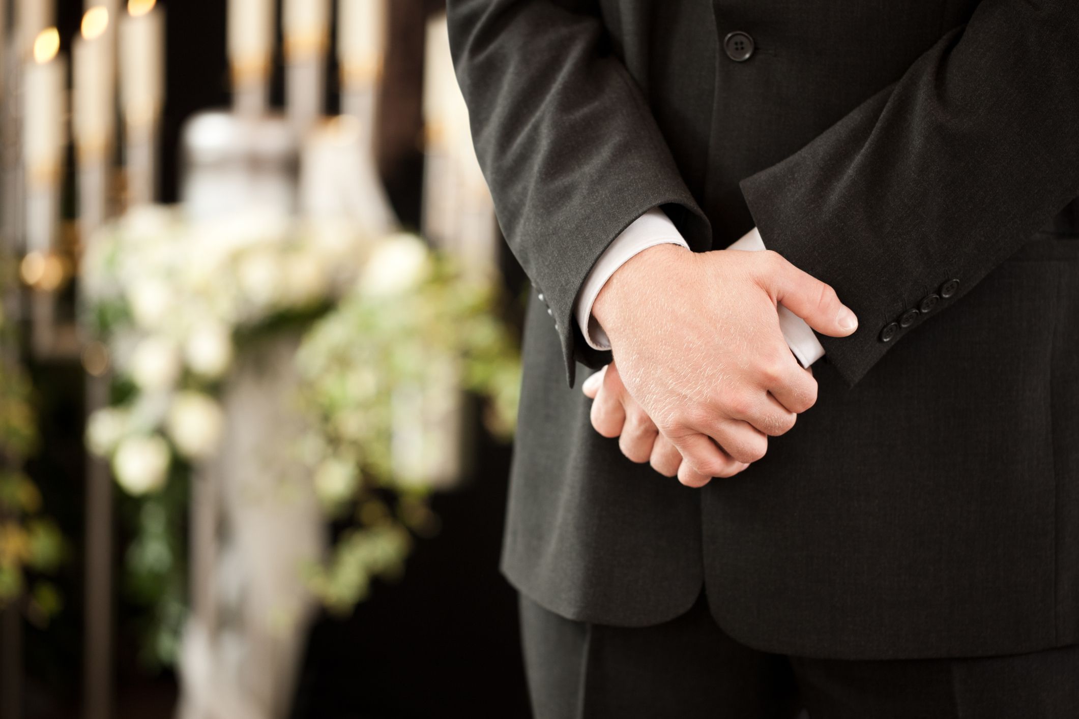 Un homme à un enterrement, les mains jointes. | Photo : Getty Images