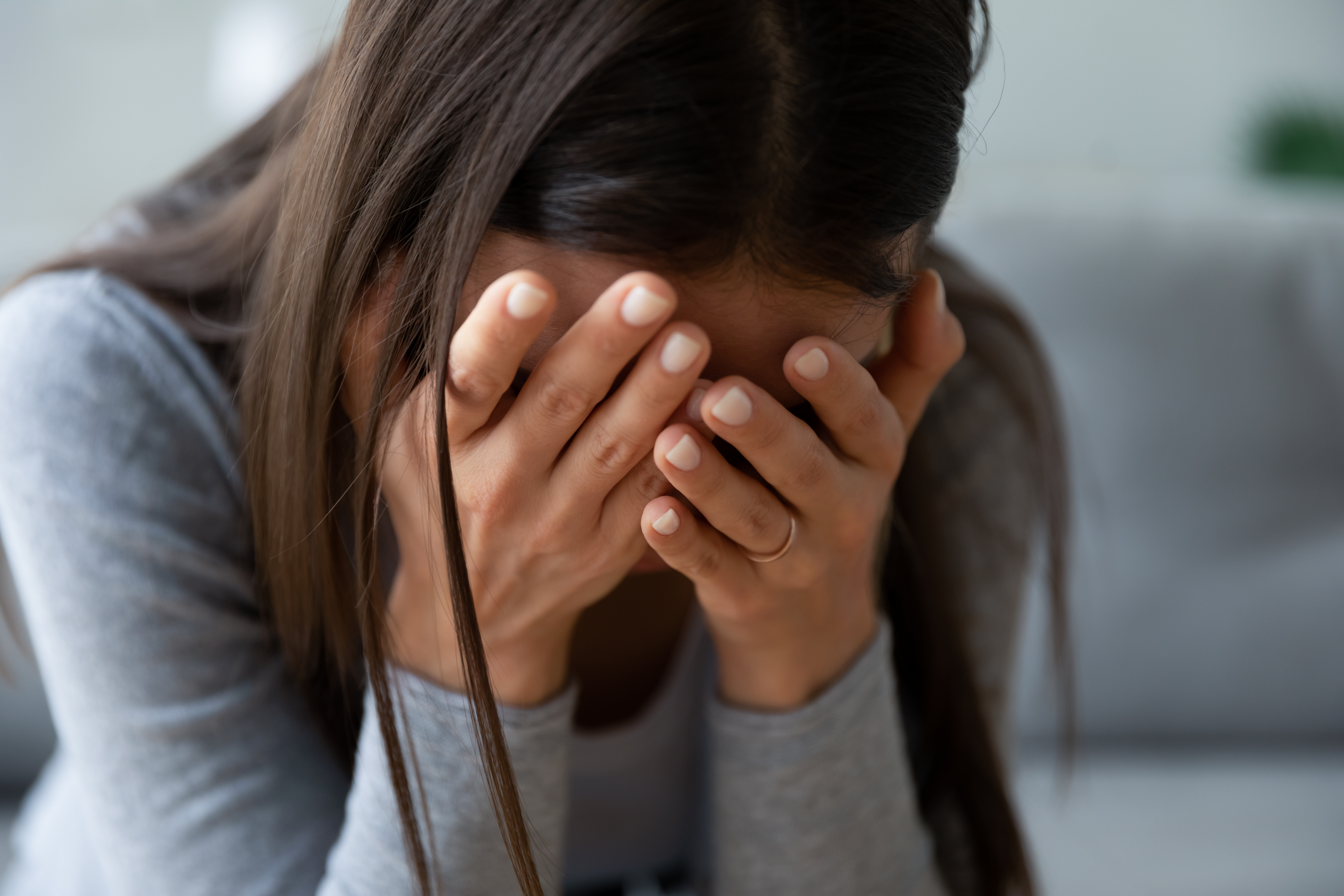 Une femme déprimée qui cache son visage avec ses mains | Source : Shutterstock