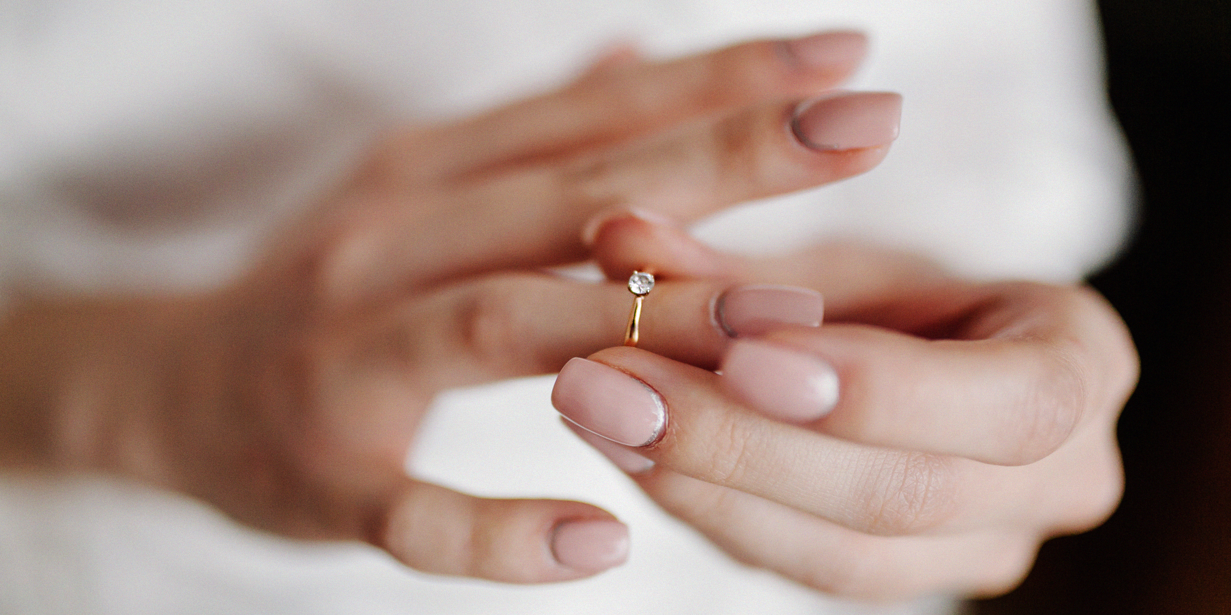 Une femme tenant une bague de fiançailles à travers son doigt | Source : Freepik