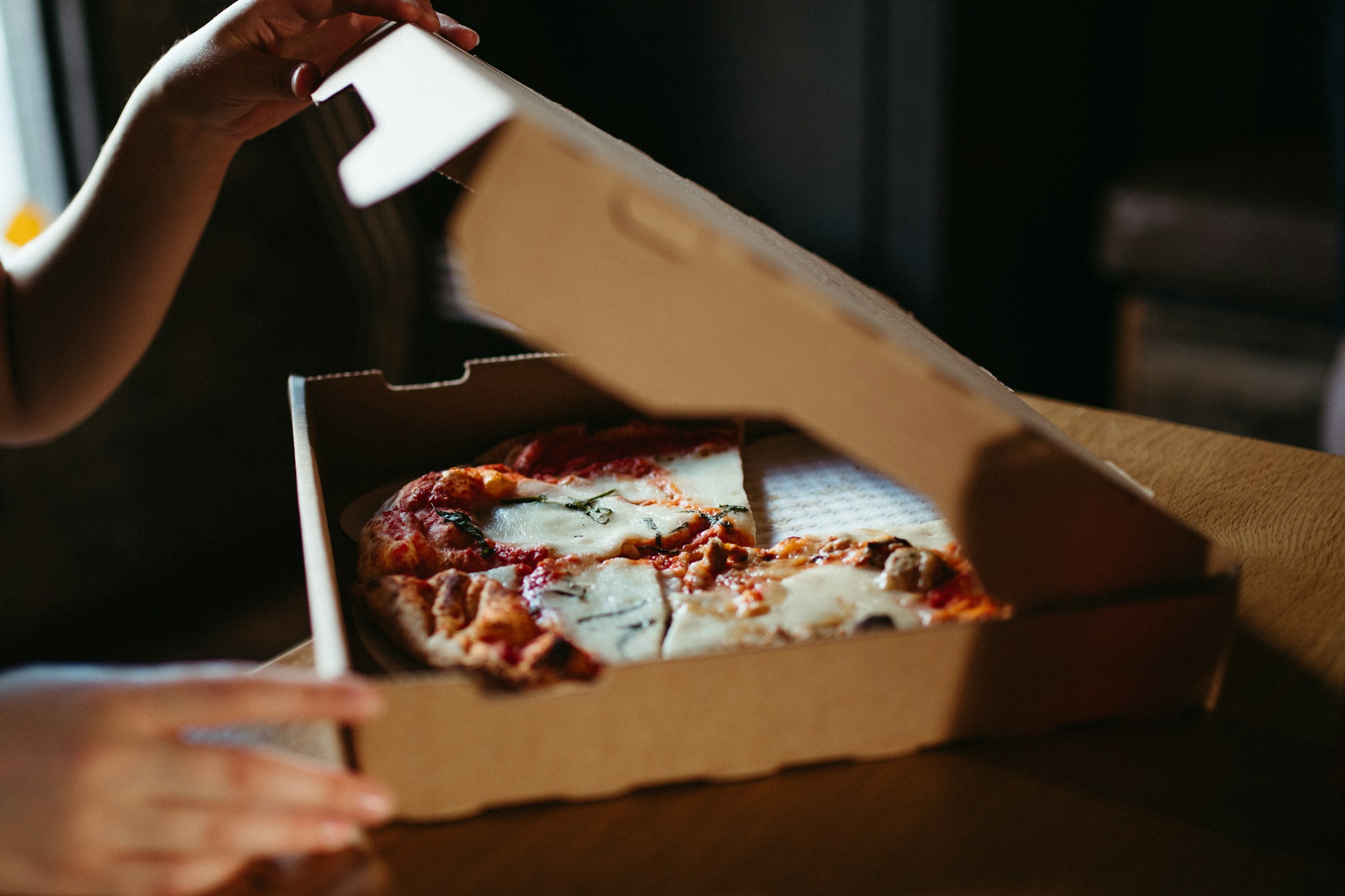 Une personne ouvrant une boîte de pizza | Source : Pexels