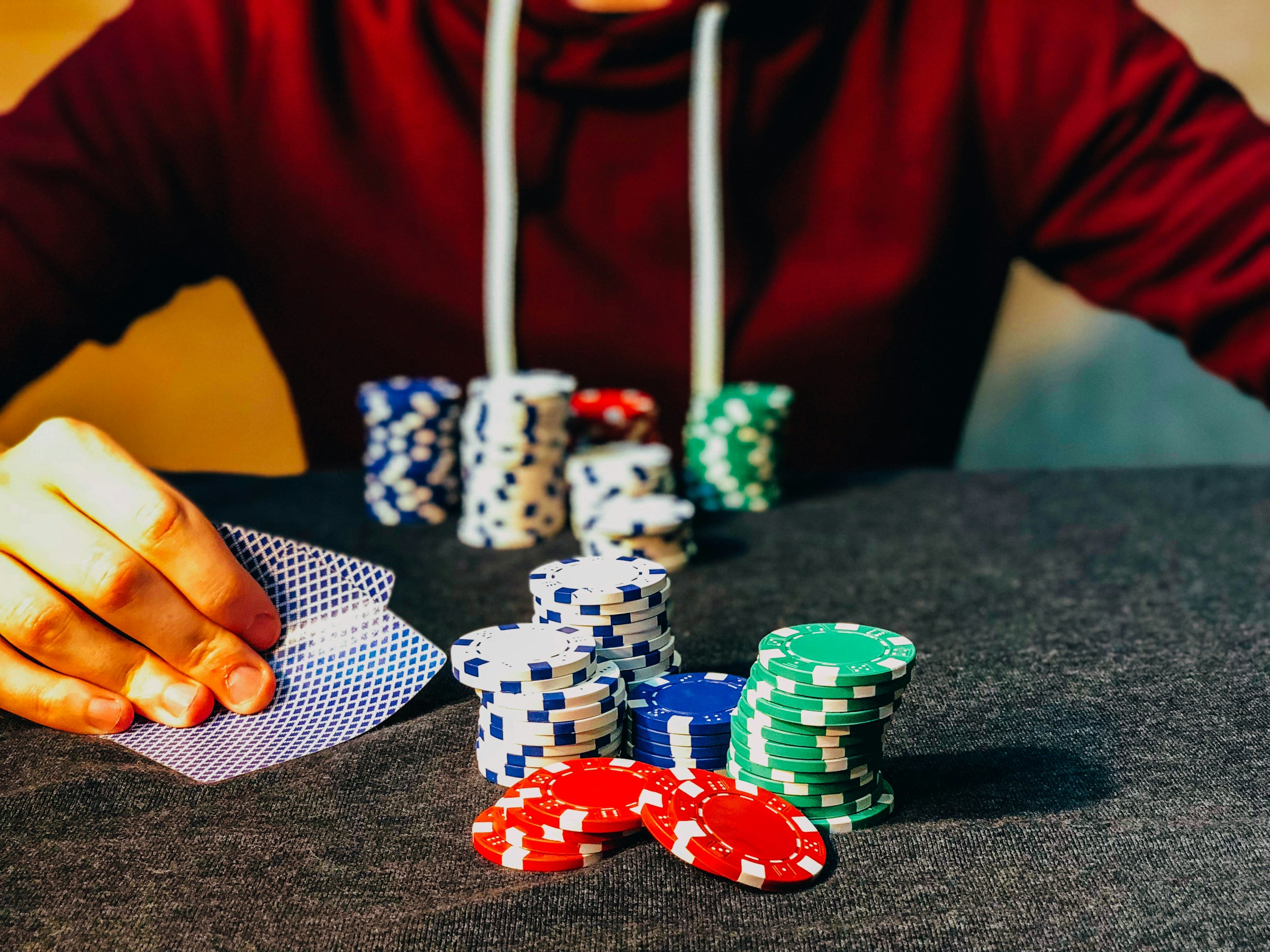 Un homme dans un casino, assis avec des jetons de poker | Source : Unsplash