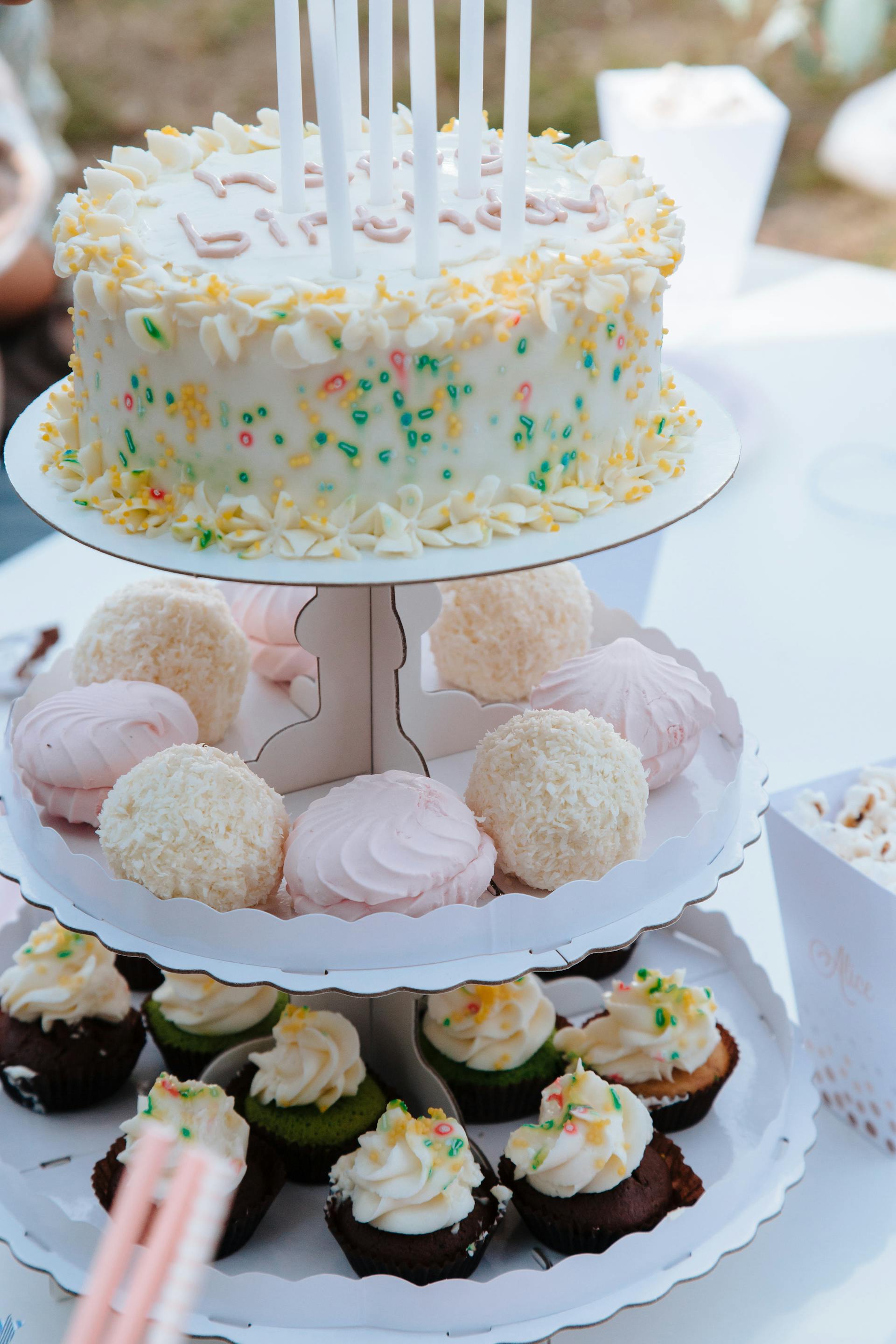 Cupcakes et gâteau d'anniversaire sur un présentoir à gâteaux | Source : Pexels