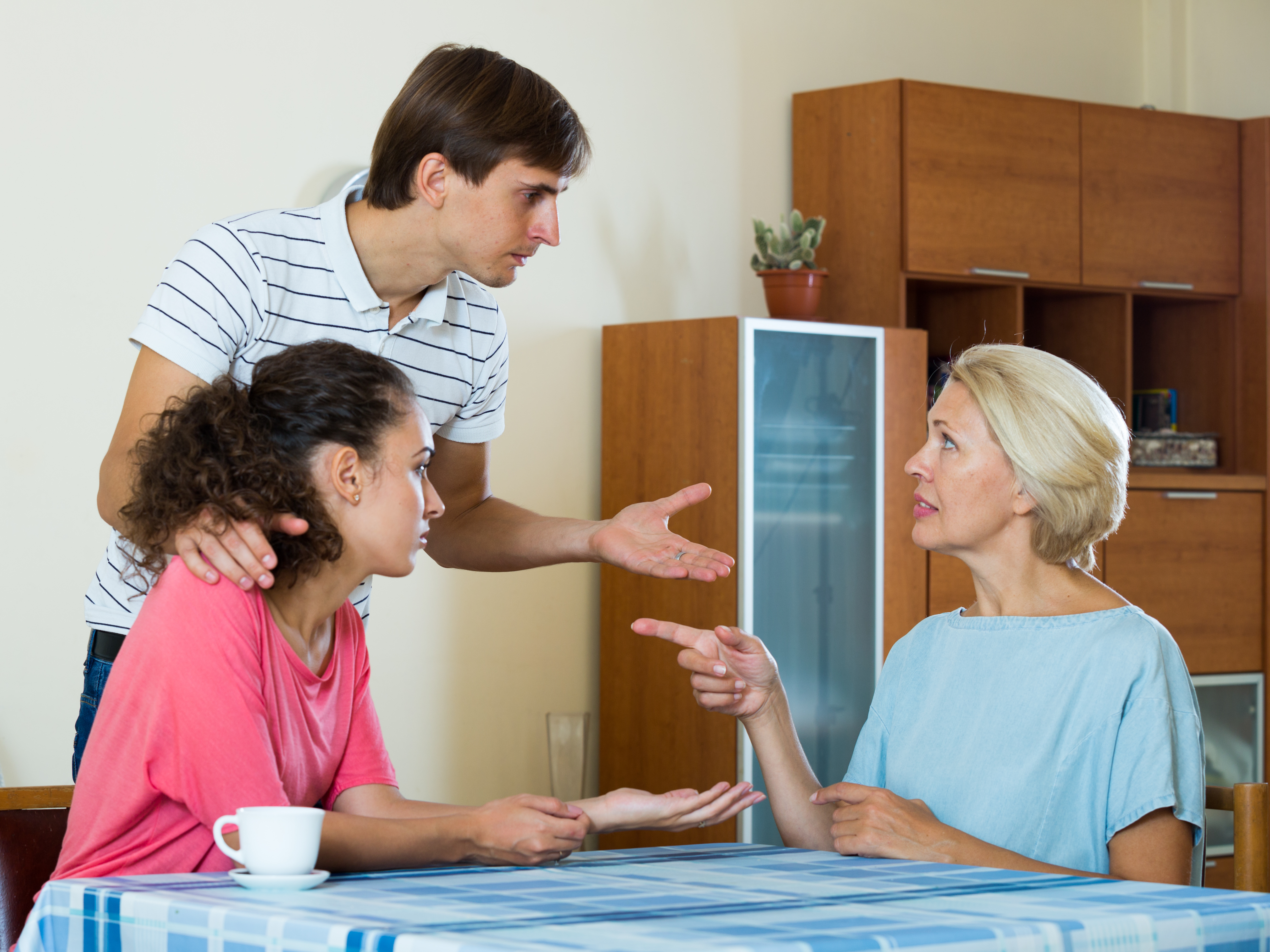 Un couple marié ayant une discussion sérieuse avec une mère âgée | Source : Shutterstock