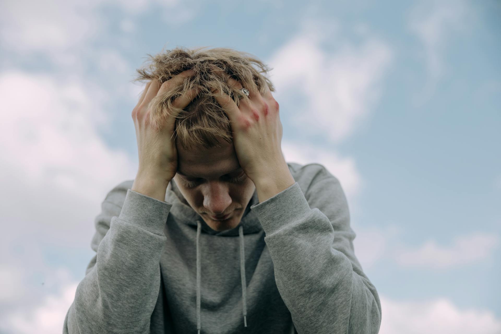 Un homme assis, la tête dans les mains | Source : Pexels