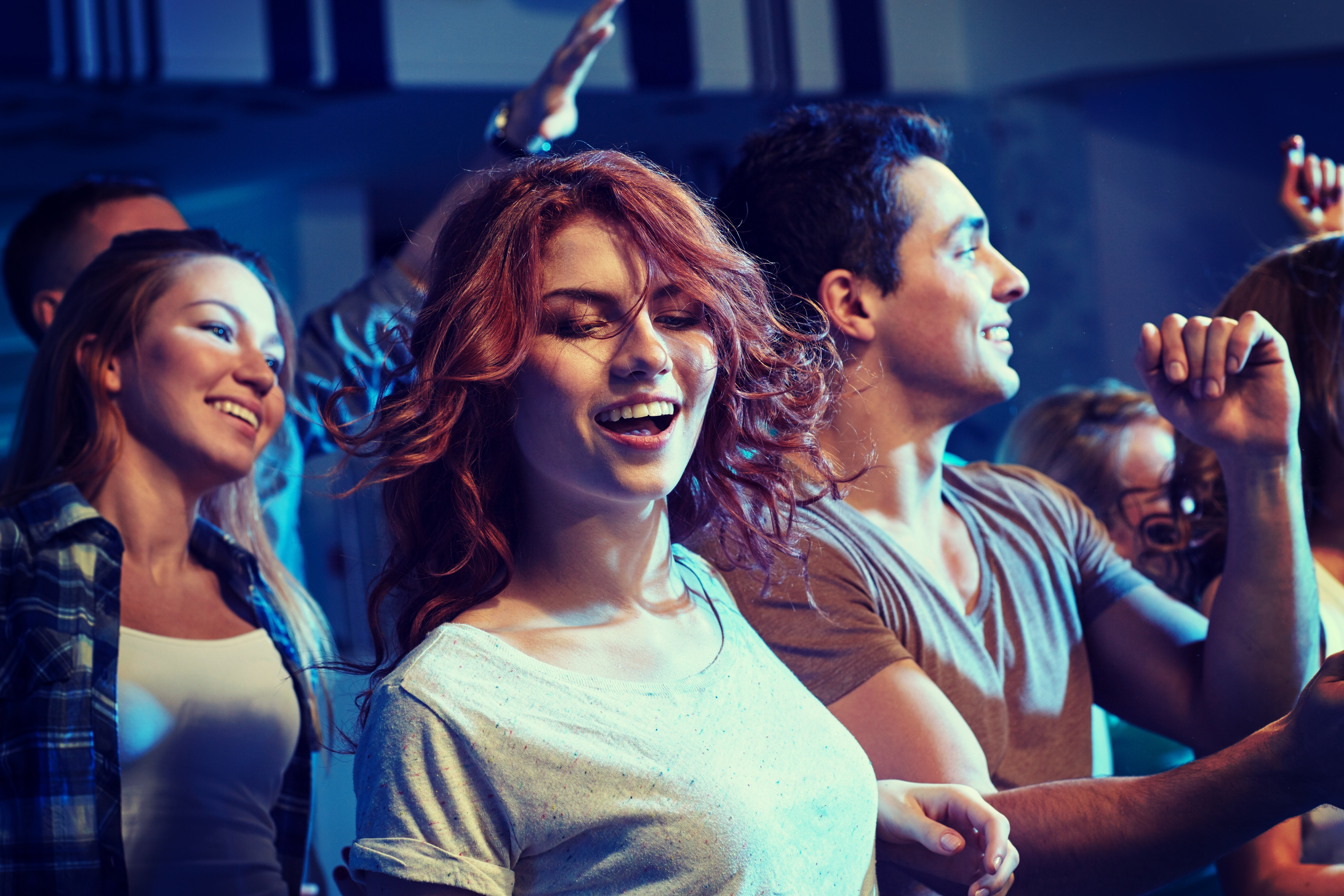 Chica bailando entre la multitud | Fuente: Shutterstock