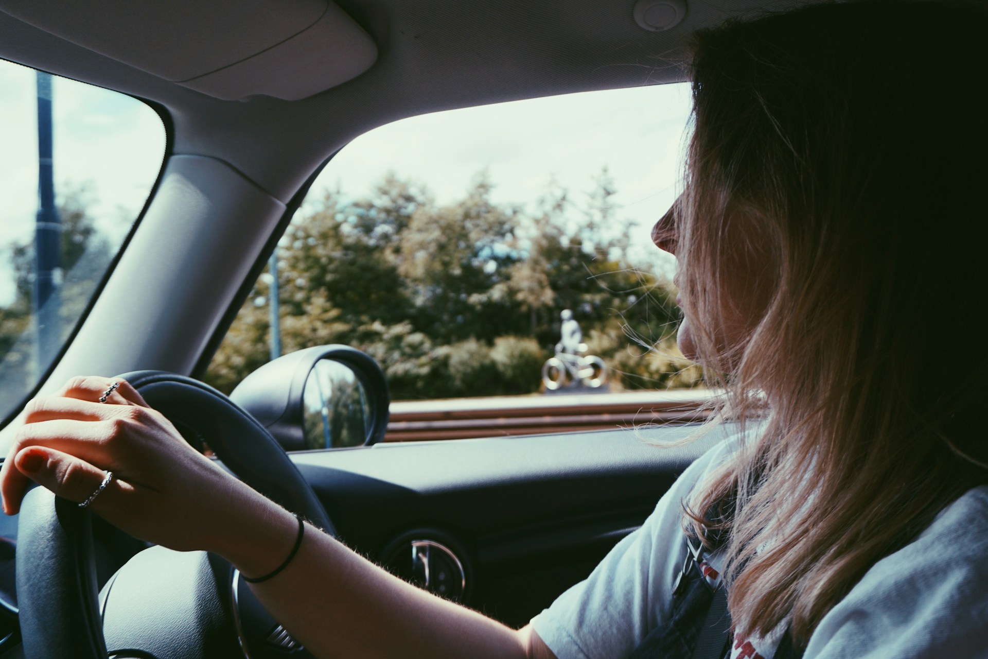 Une femme joyeuse au volant d'une voiture | Source : Unsplash