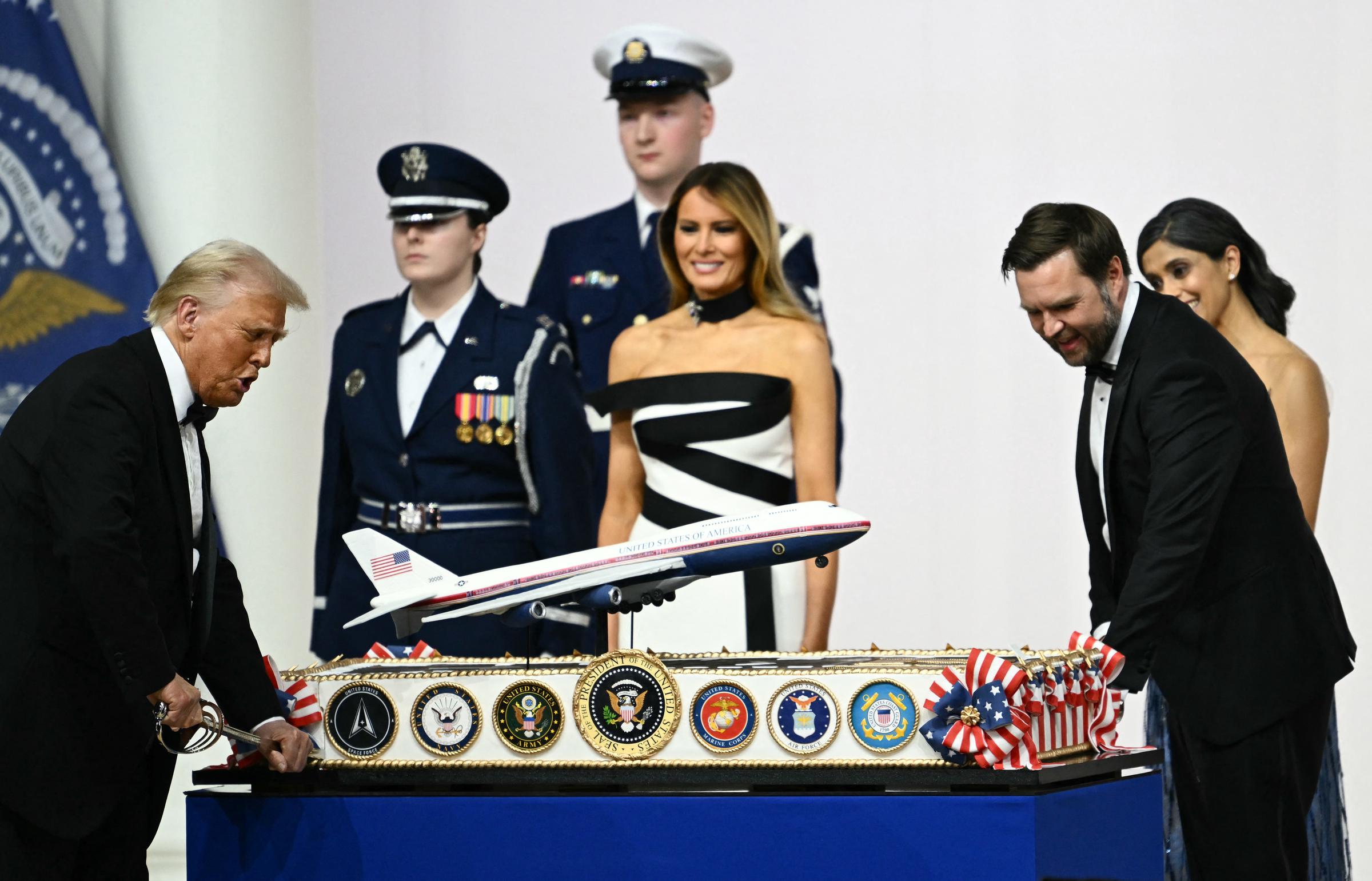 La première dame Melania Trump à côté d'Usha Vance regarde le président américain Donald Trump et le vice-président J.D. Vance découper un gâteau représentant le nouveau design d'Air Force One avec un sabre, lors du bal inaugural du commandant en chef, le 20 janvier 2025 | Source : Getty Images