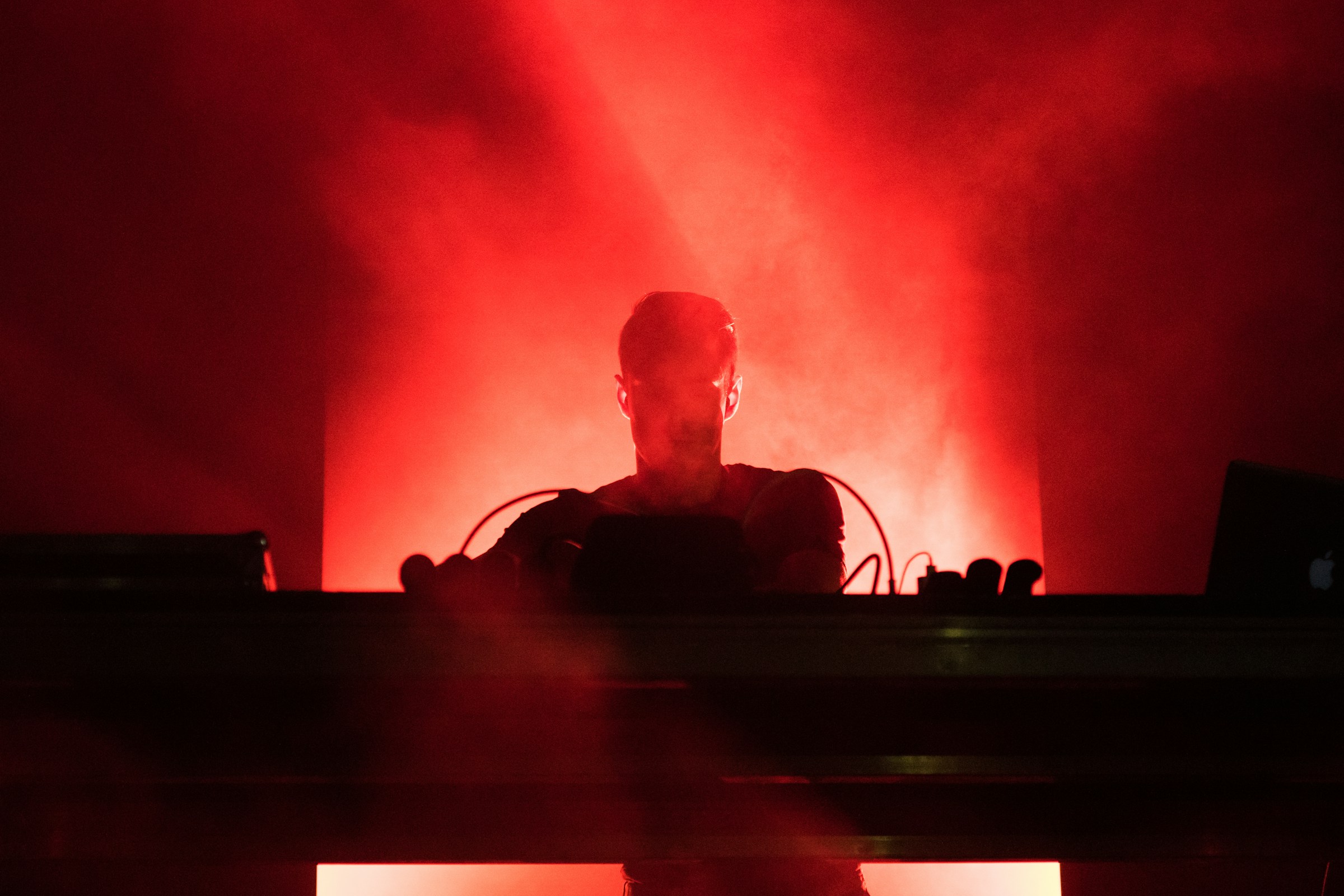 DJ jouant de la musique sous des lumières rouges | Source : Unsplash