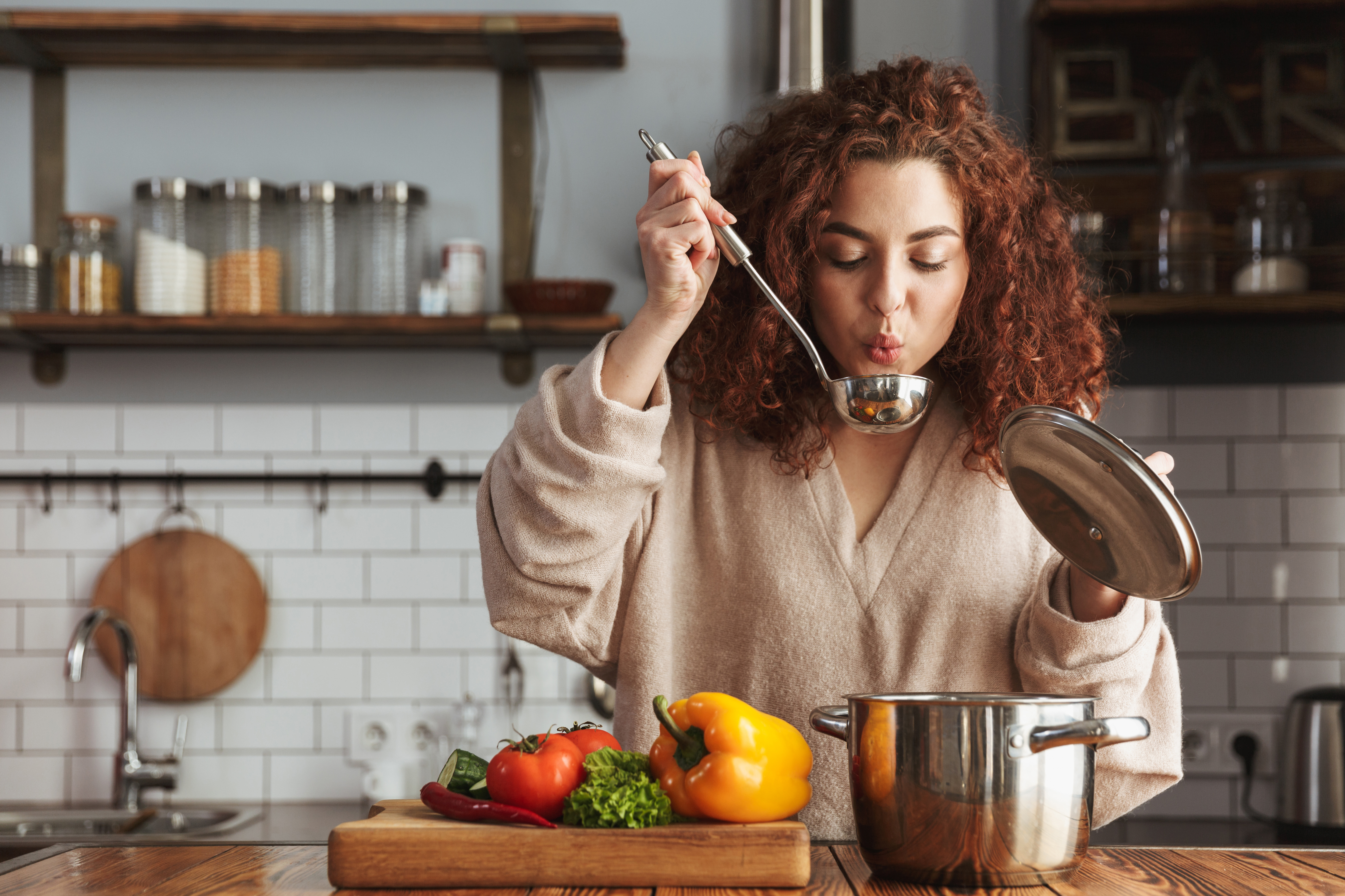 Une femme qui goûte la nourriture qu'elle a cuisinée | Source : Shutterstock