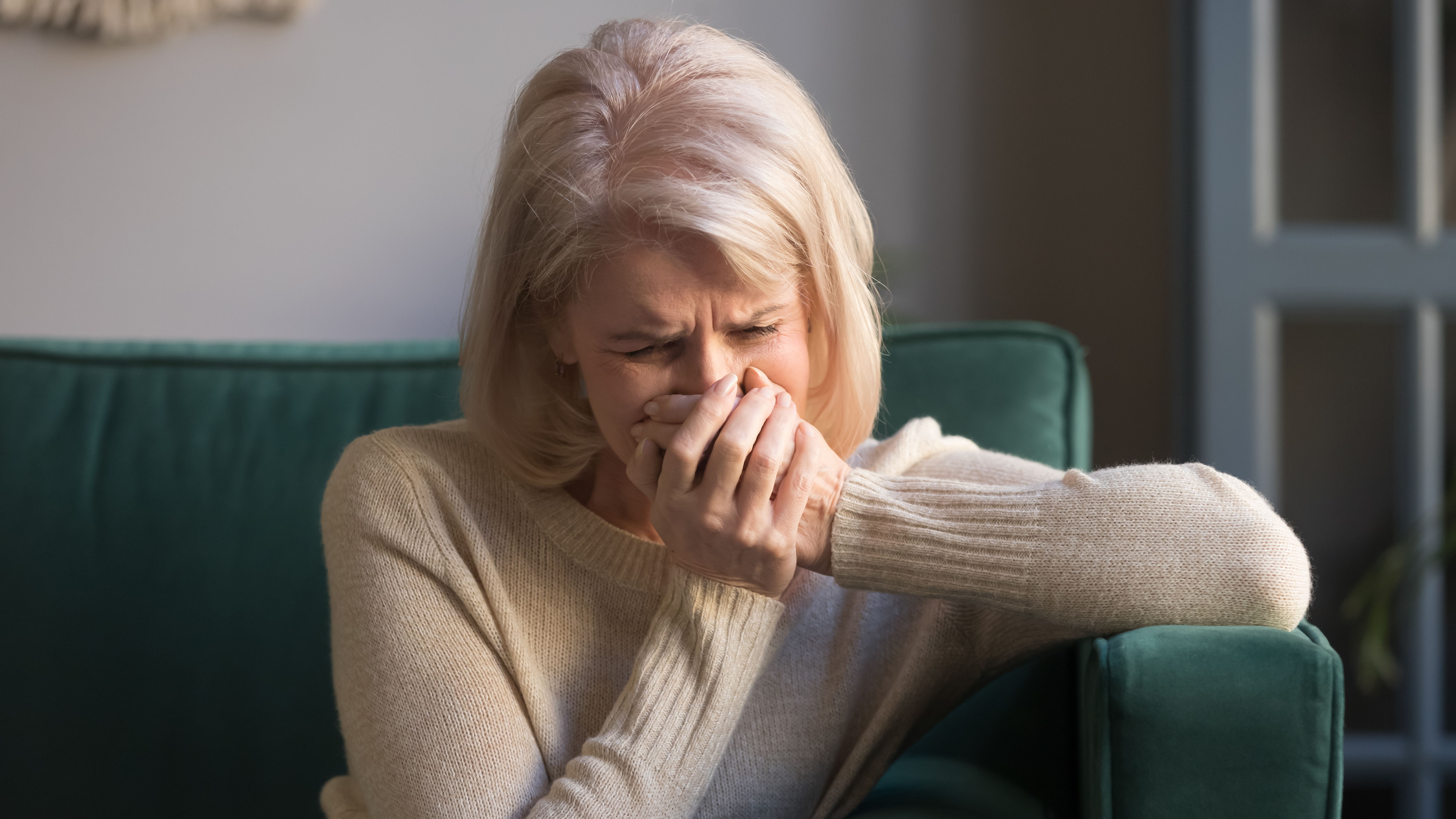 Femme âgée stressée pleurant seule chez elle | Source : Shutterstock