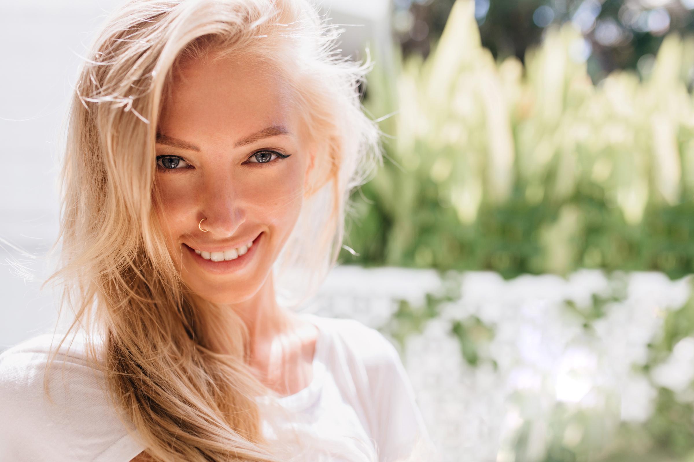 Une femme blonde souriante | Source : Freepik