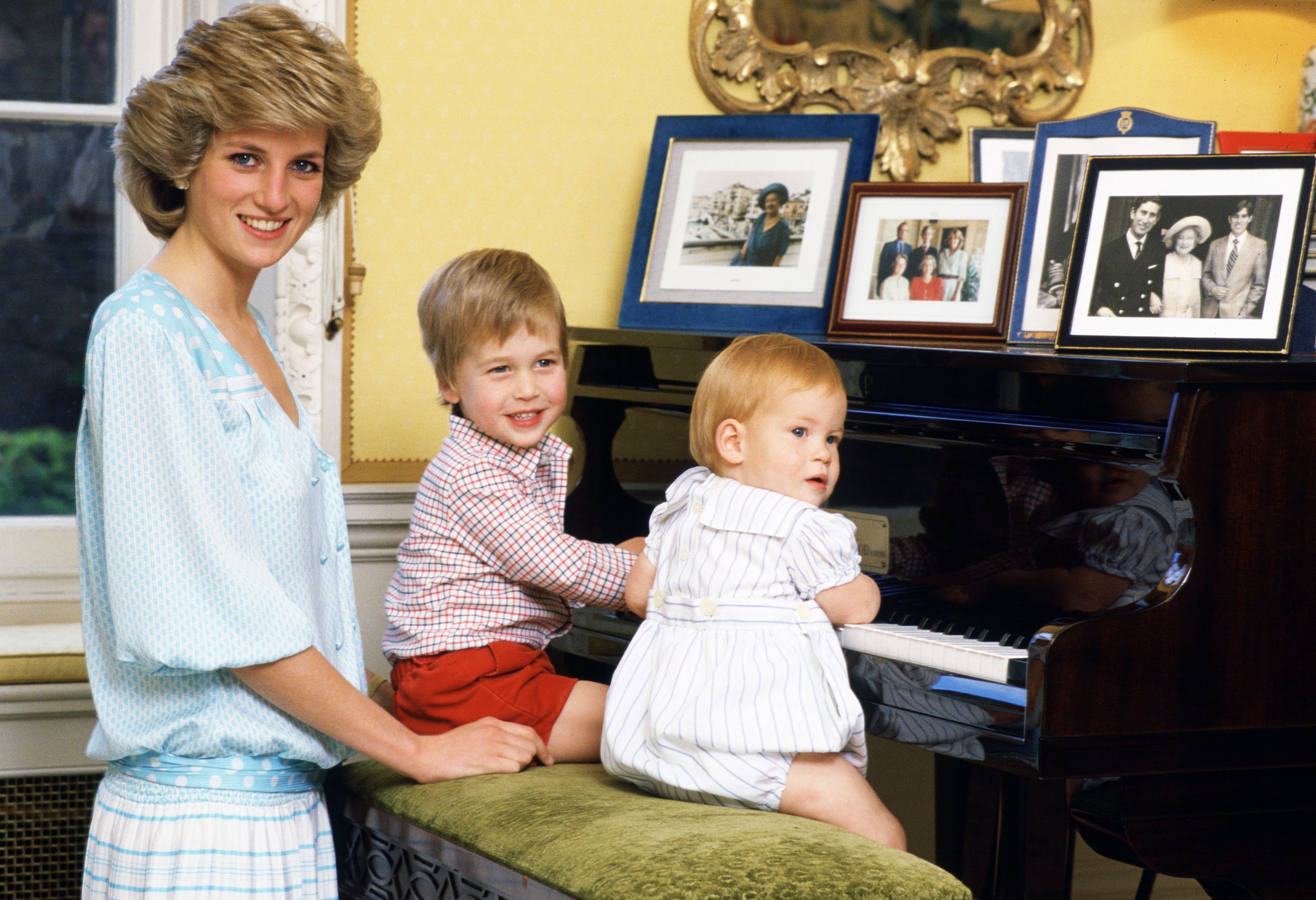 Diana, princesse de Galles, avec ses fils, le prince William et le prince Harry, photographiés en train de jouer du piano au palais de Kensington. | Source : Getty Images          
