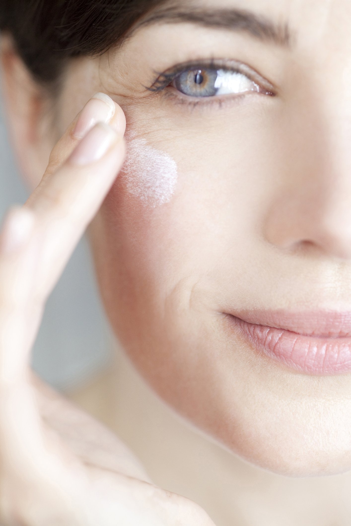 Une femme applique une crème sur son visage. | Photo : Getty Images