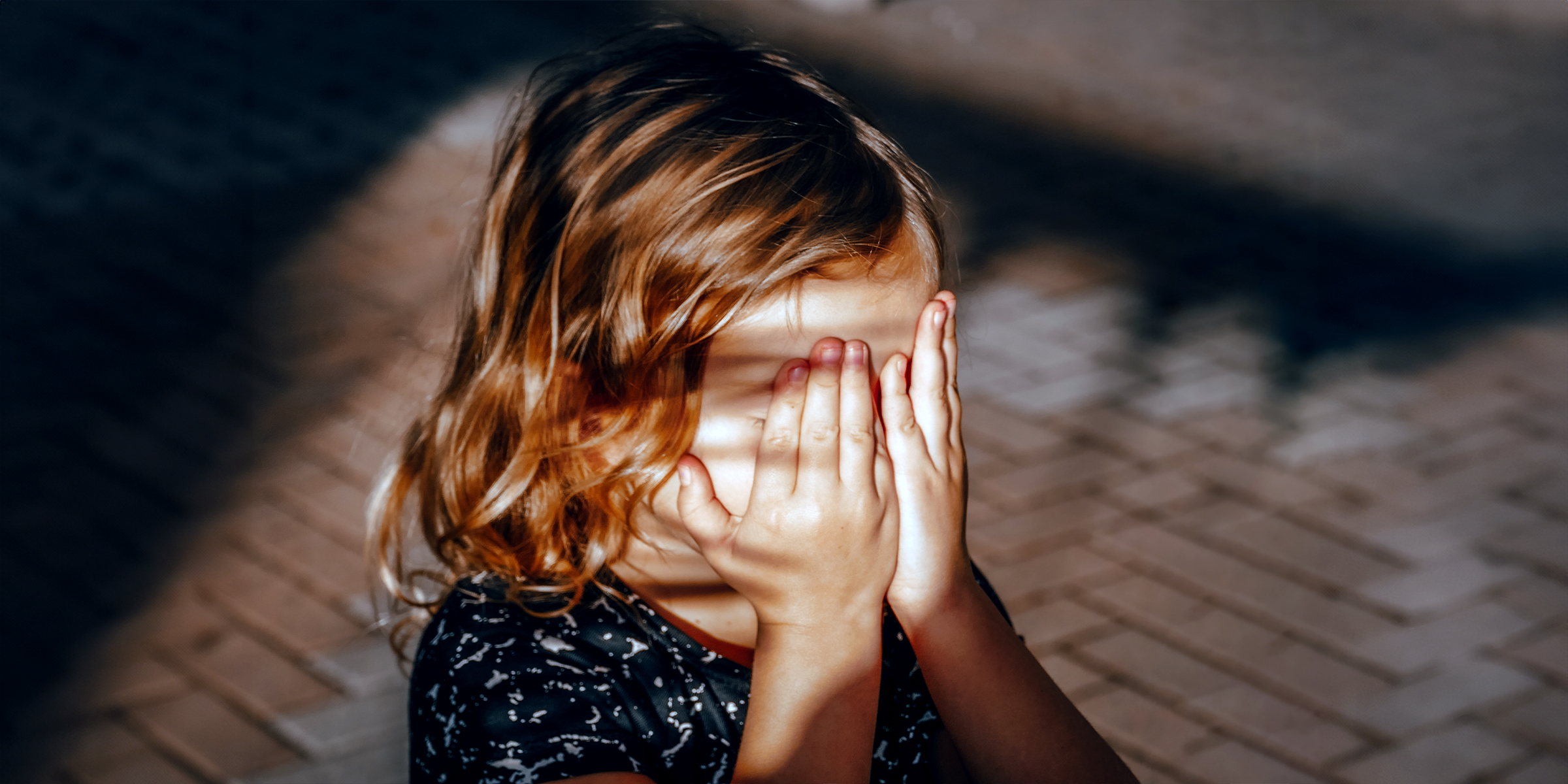 Une fille cache son visage avec ses mains | Source : Shutterstock