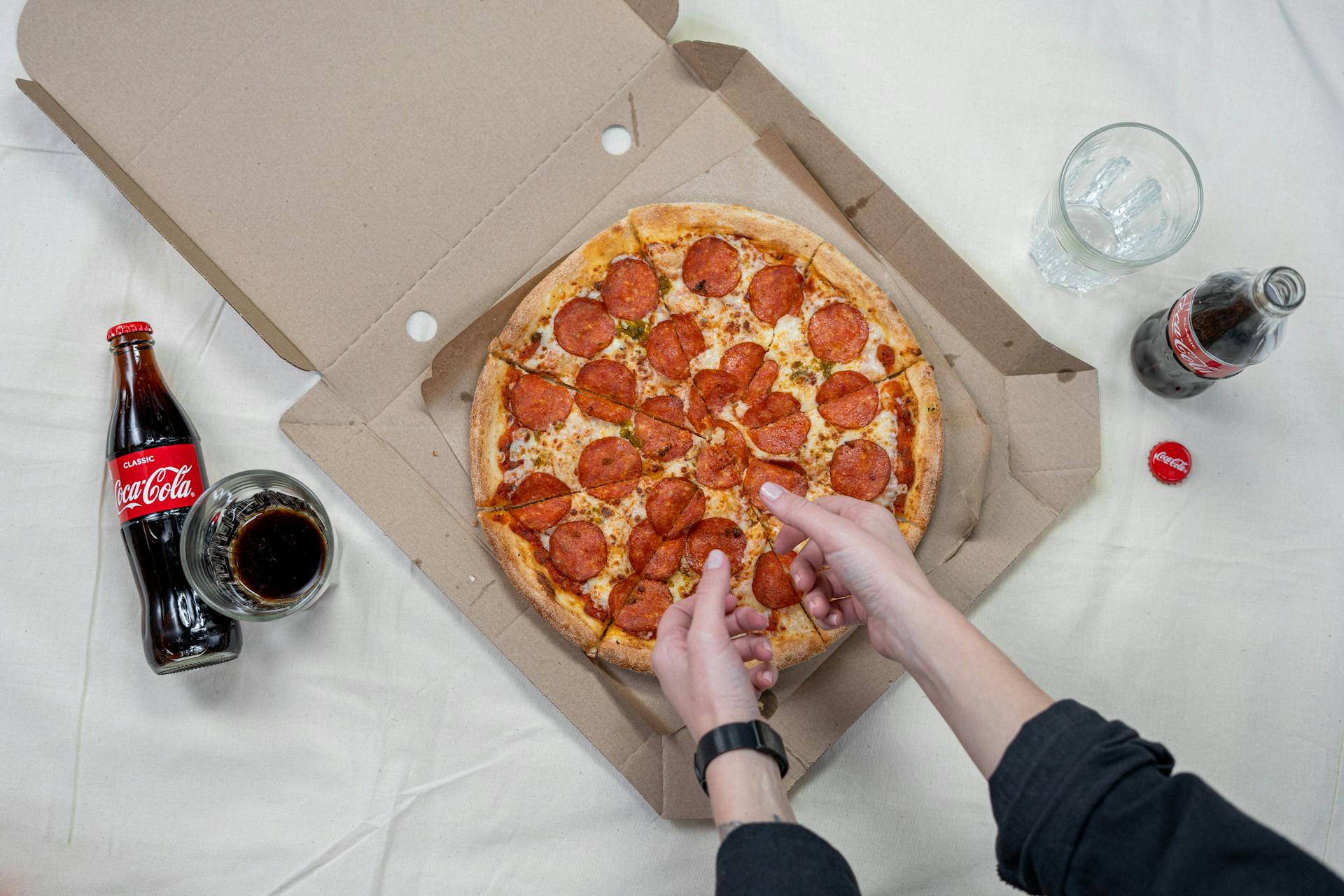 Une personne prenant une part de pizza | Source : Pexels