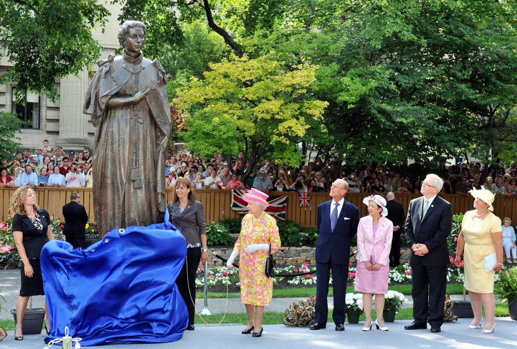 La reine Elizabeth II de Grande-Bretagne alors qu'elle dévoile une statue d'elle-même dans le jardin de Government House, lors d'une visite à Winnipeg, Canada. | Photo : Getty Images