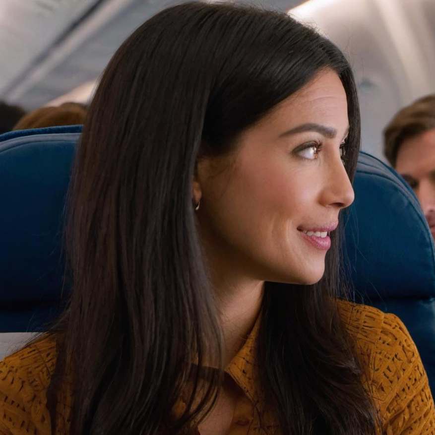 Une femme en pleine conversation à bord d'un avion | Source : Midjourney