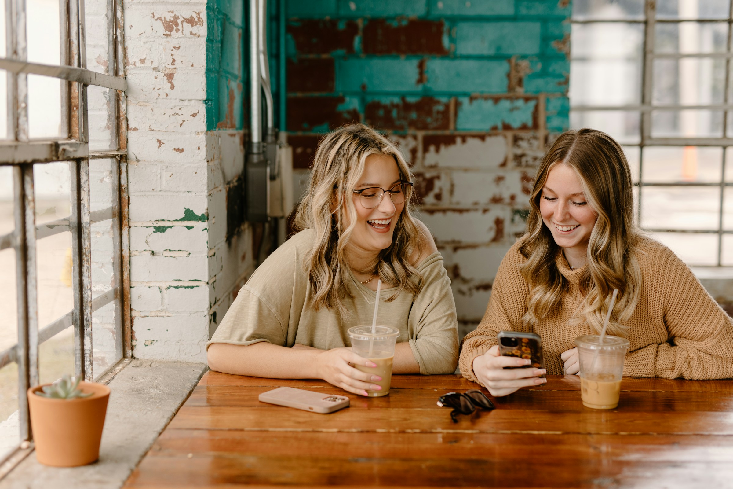 Amis prenant un café et souriant | Source : Unsplash