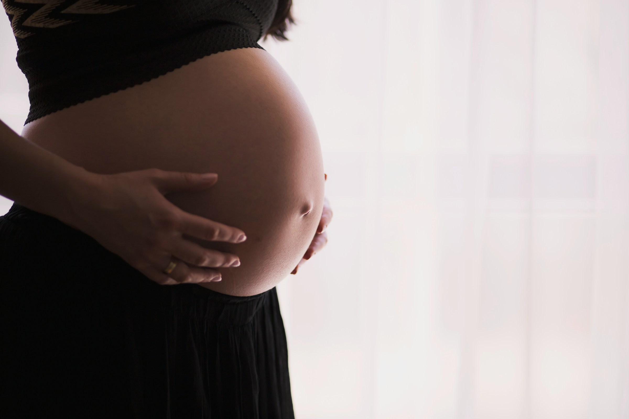 A pregnant woman holding her stomach | Source: Unsplash