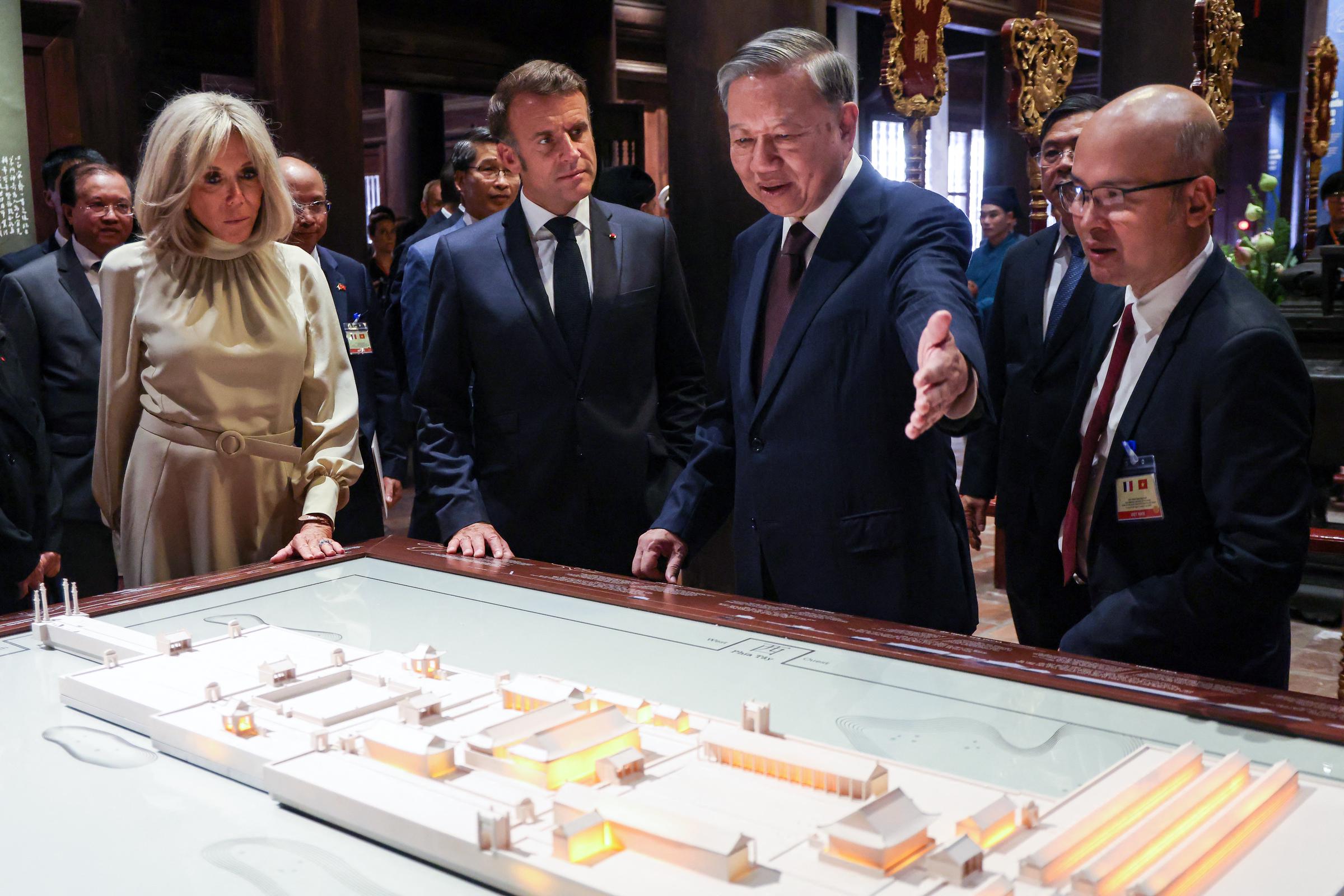 Le président français Emmanuel Macron (2e à gauche), son épouse Brigitte Macron (à gauche) et le secrétaire général du Parti communiste vietnamien To Lam (au centre à droite) visitent le Temple de la Littérature à Hanoï, le 26 mai 2025 I Source : Getty Images