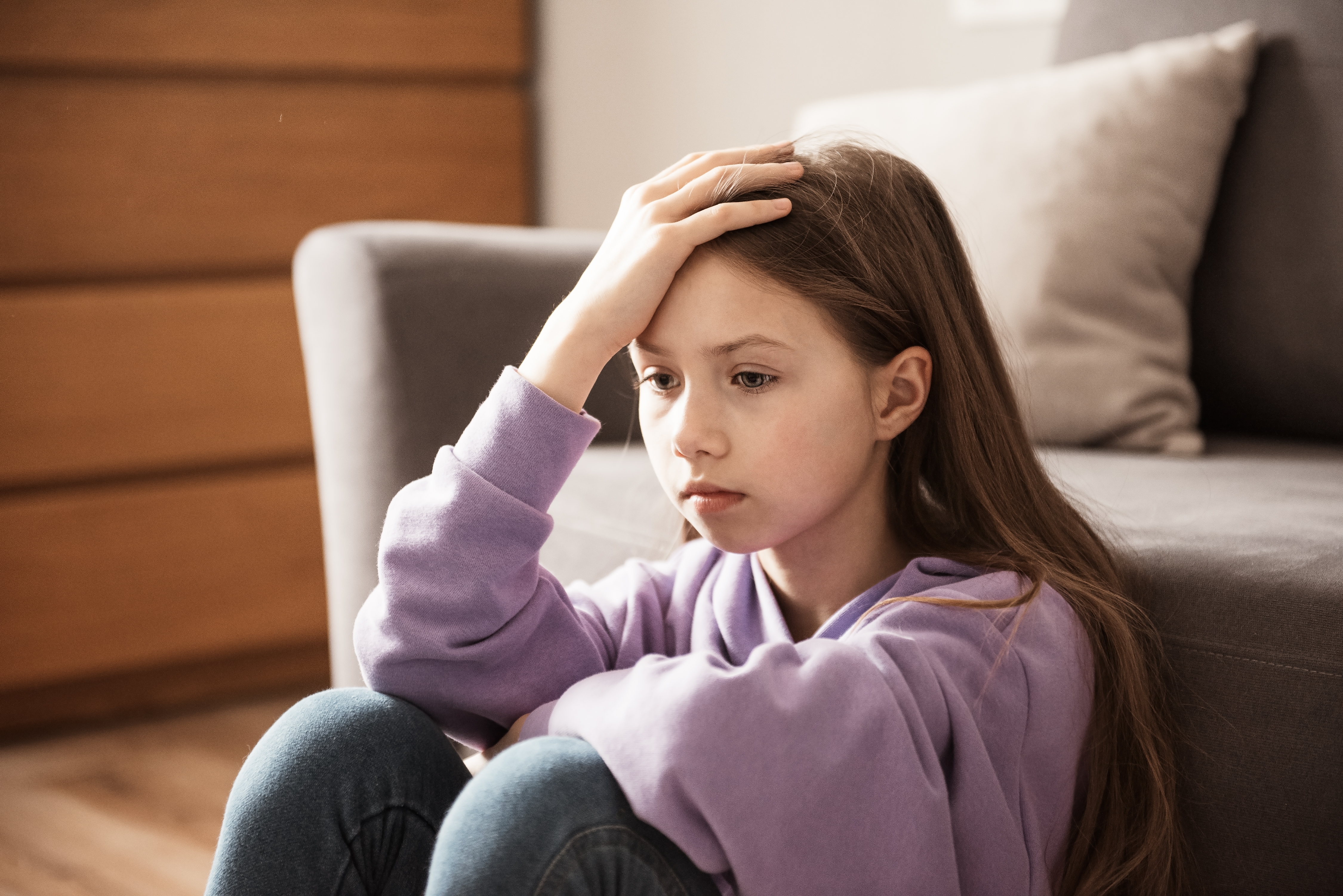 Une adolescente déprimée est photographiée assise à l'intérieur | Source : Shutterstock