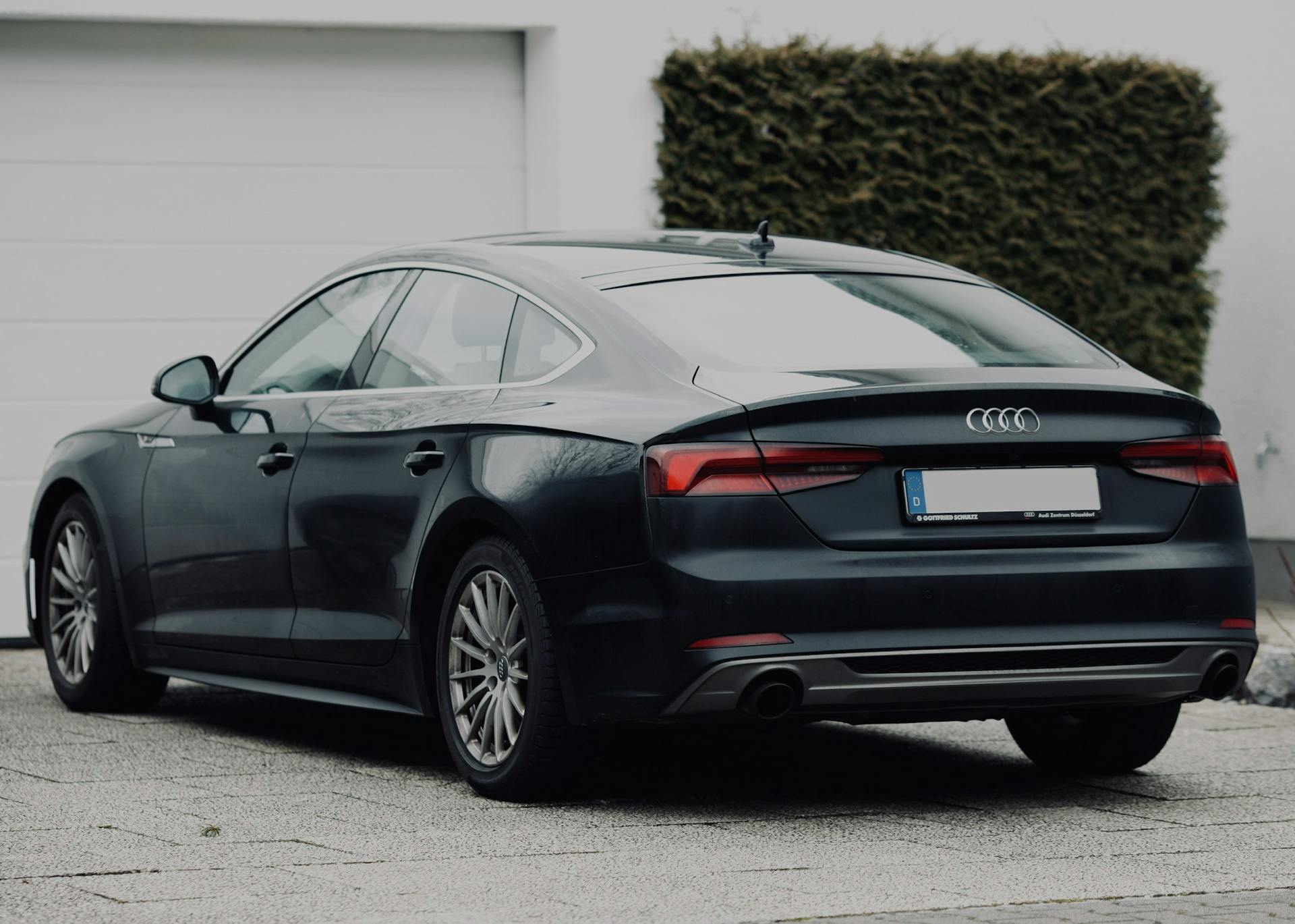 A black car parked in a driveway | Source: Pexels