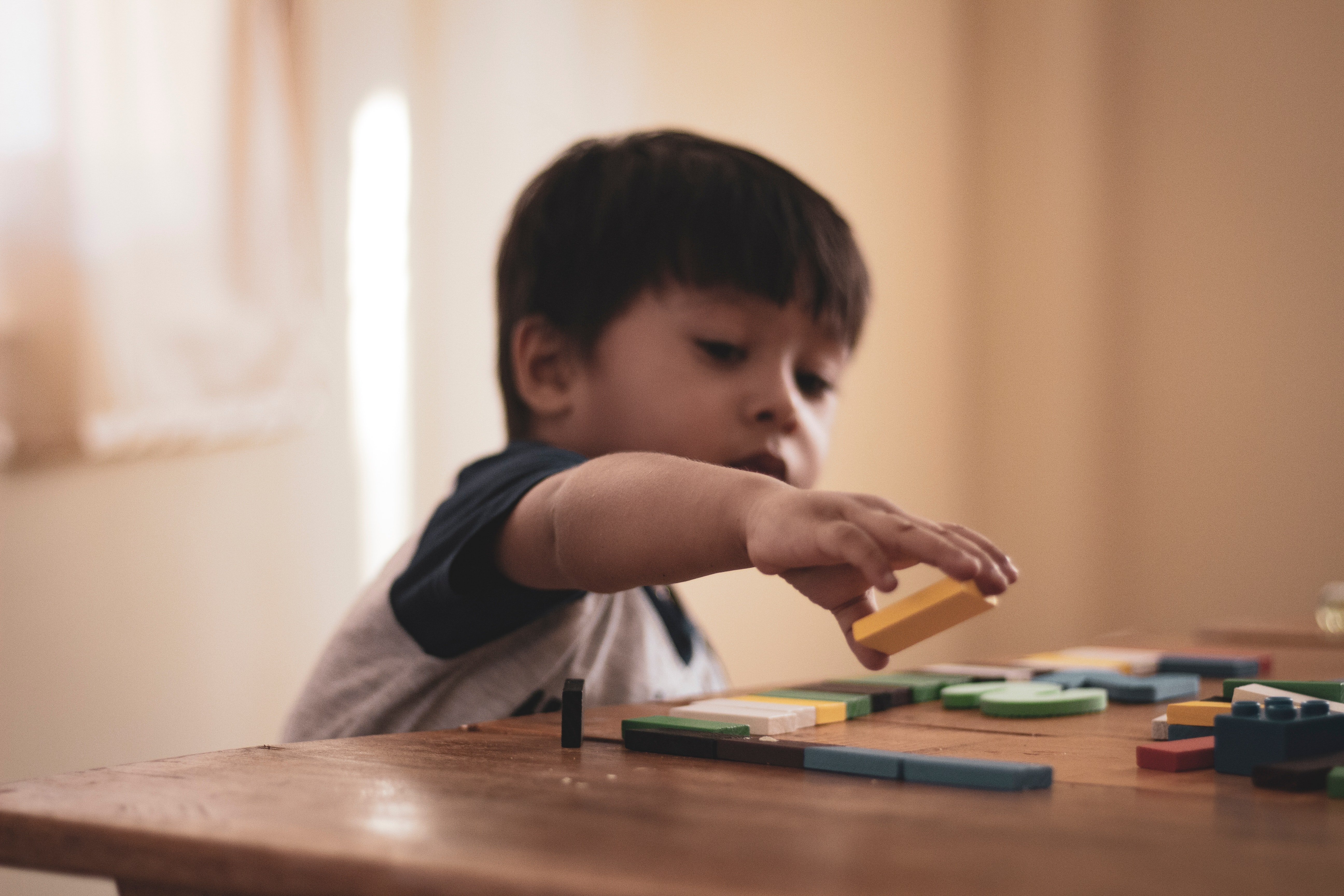 Enfant qui joue avec des blocs de bois. | Source : Pexels