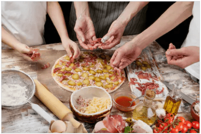 Une maman et ses enfants préparent une délicieuse pizza maison avec du prosciutto et des légumes dans leur cuisine. | Shutterstock