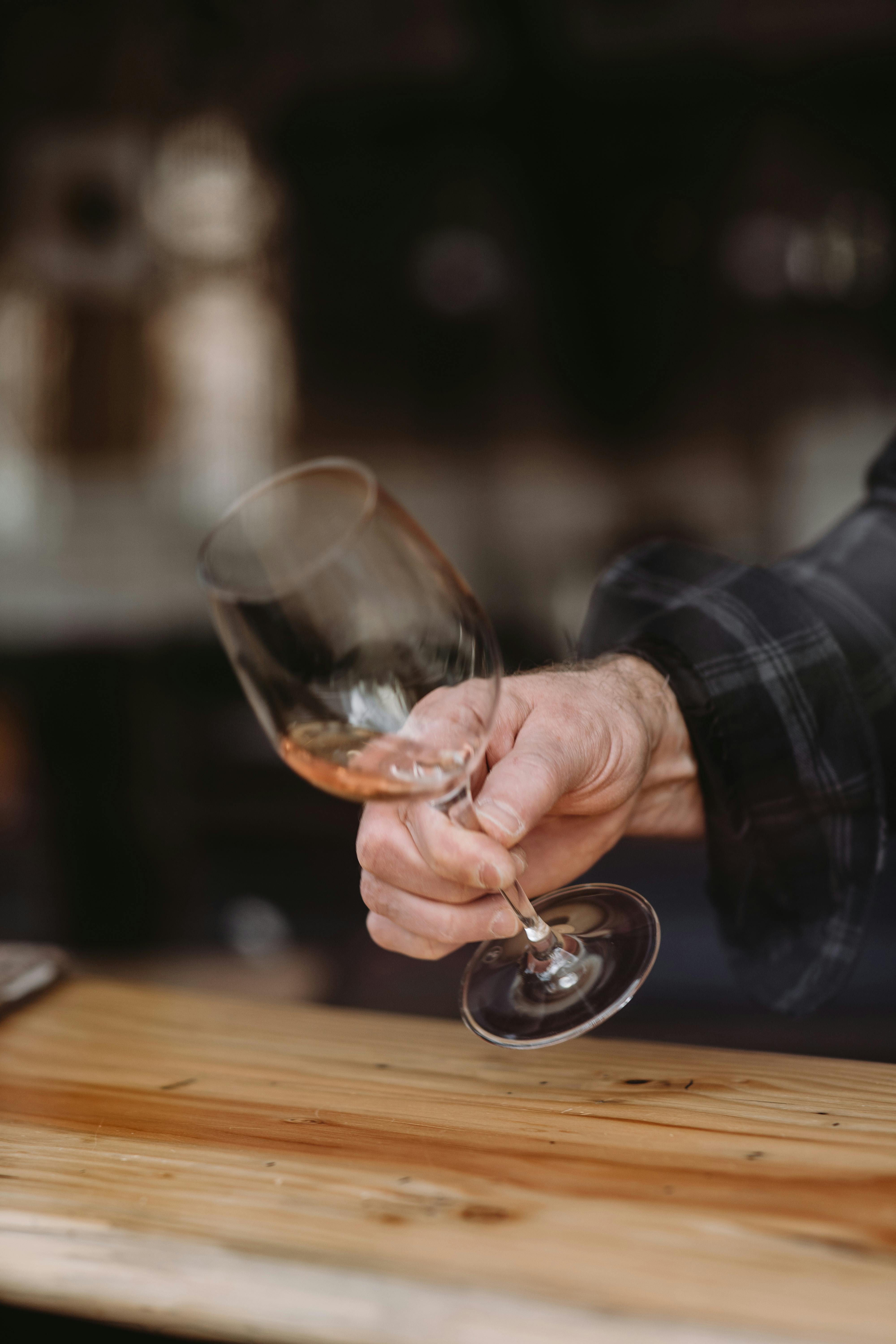 Un homme qui tend un verre de vin | Source : Pexels