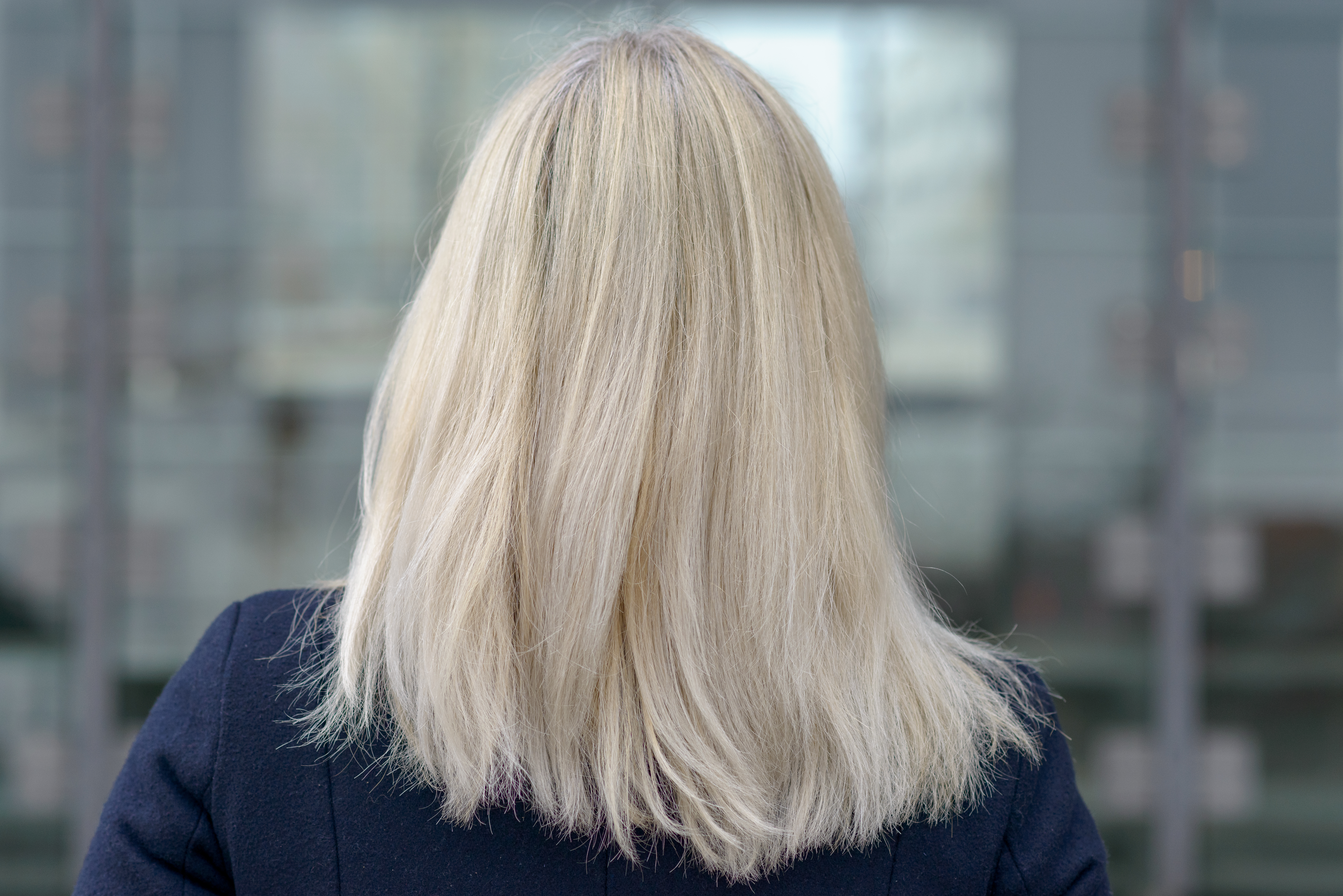Vue arrière d'une femme aux cheveux blonds mi-longs | Source : Shutterstock
