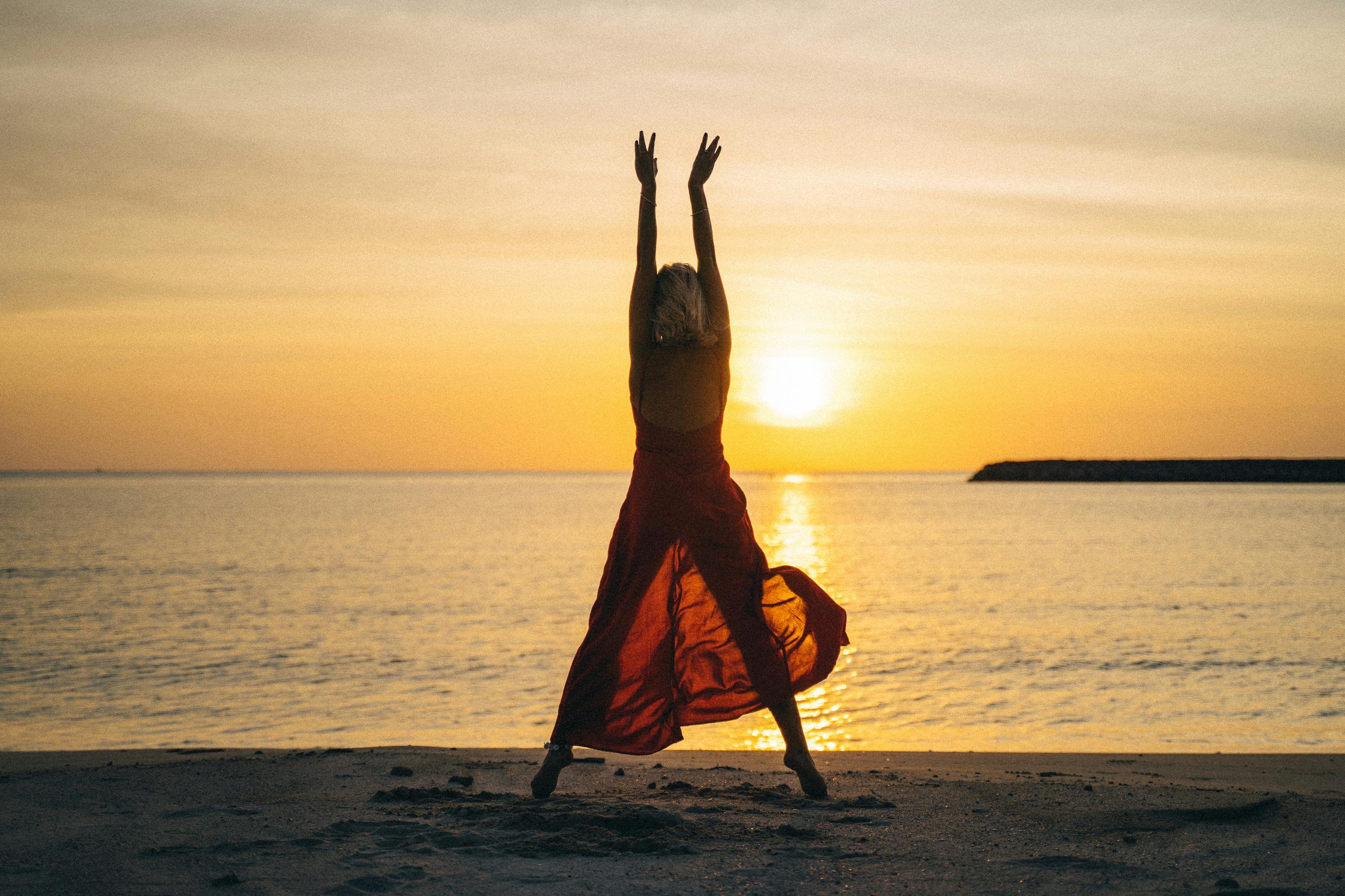 Une femme s'étirant vers le haut au coucher du soleil | Source : Pexels