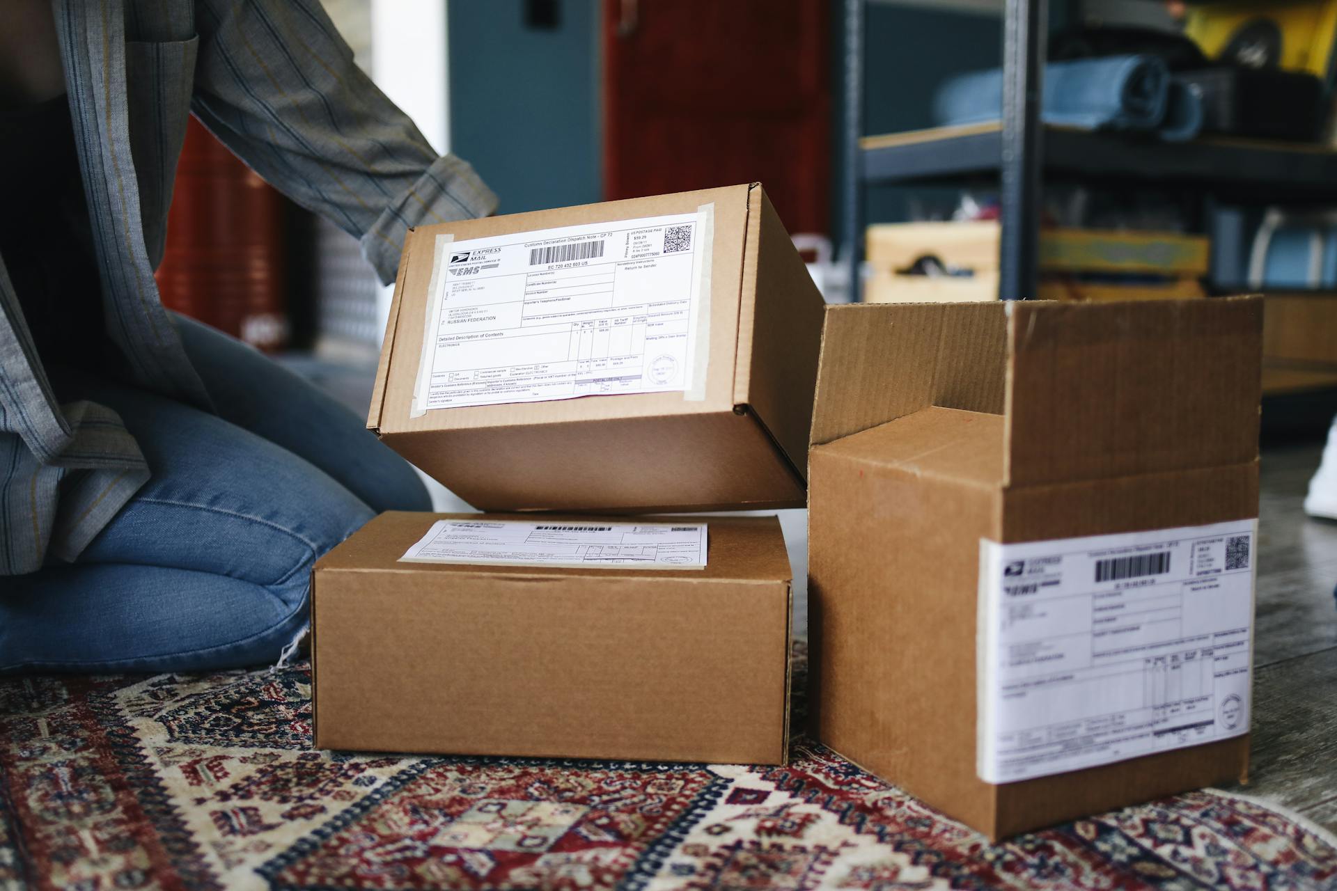 Une femme agenouillée à côté de ses colis livrés | Source : Pexels