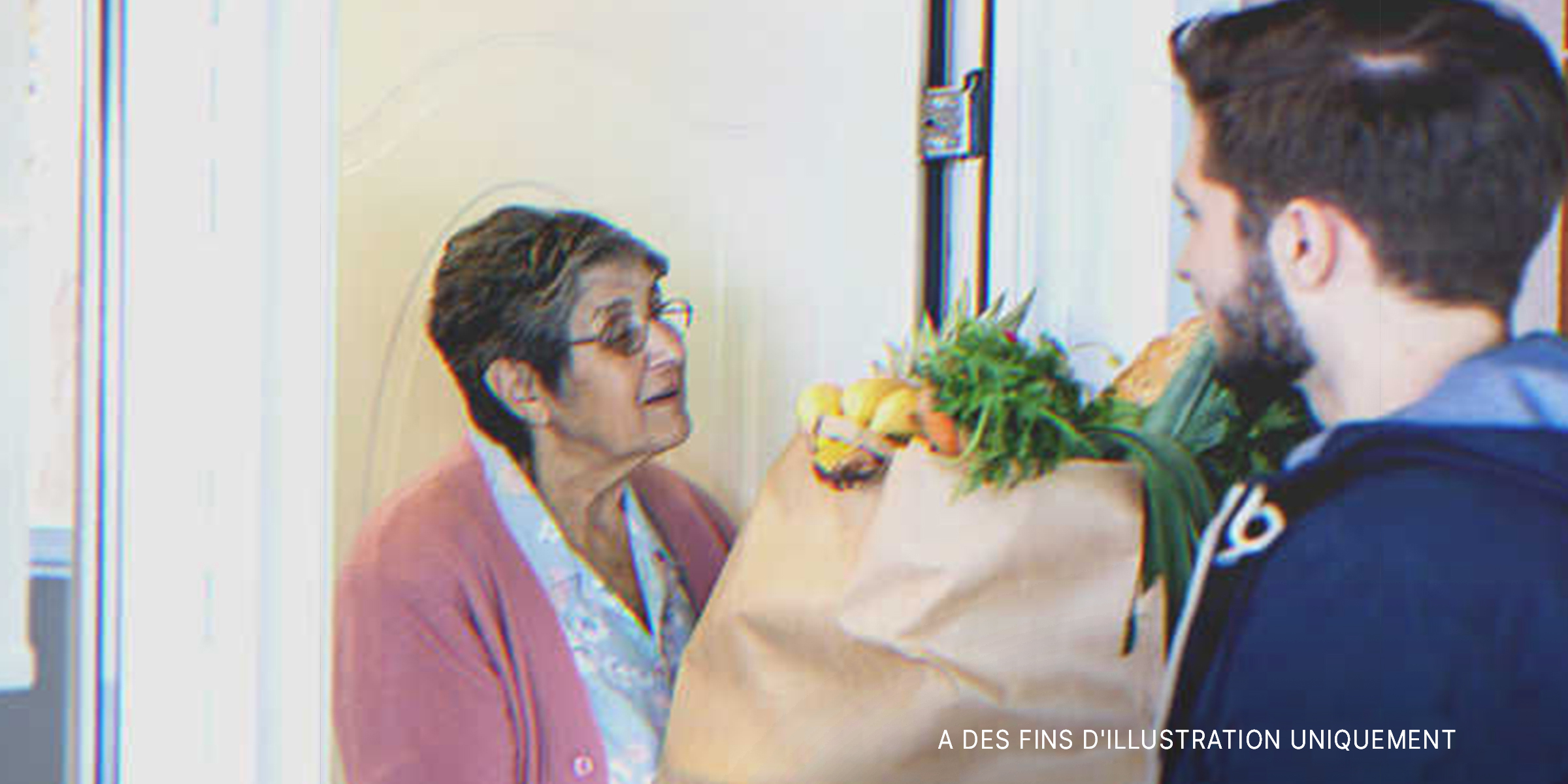 Un homme donnant des provisions à une femme âgée | Source : Getty Images