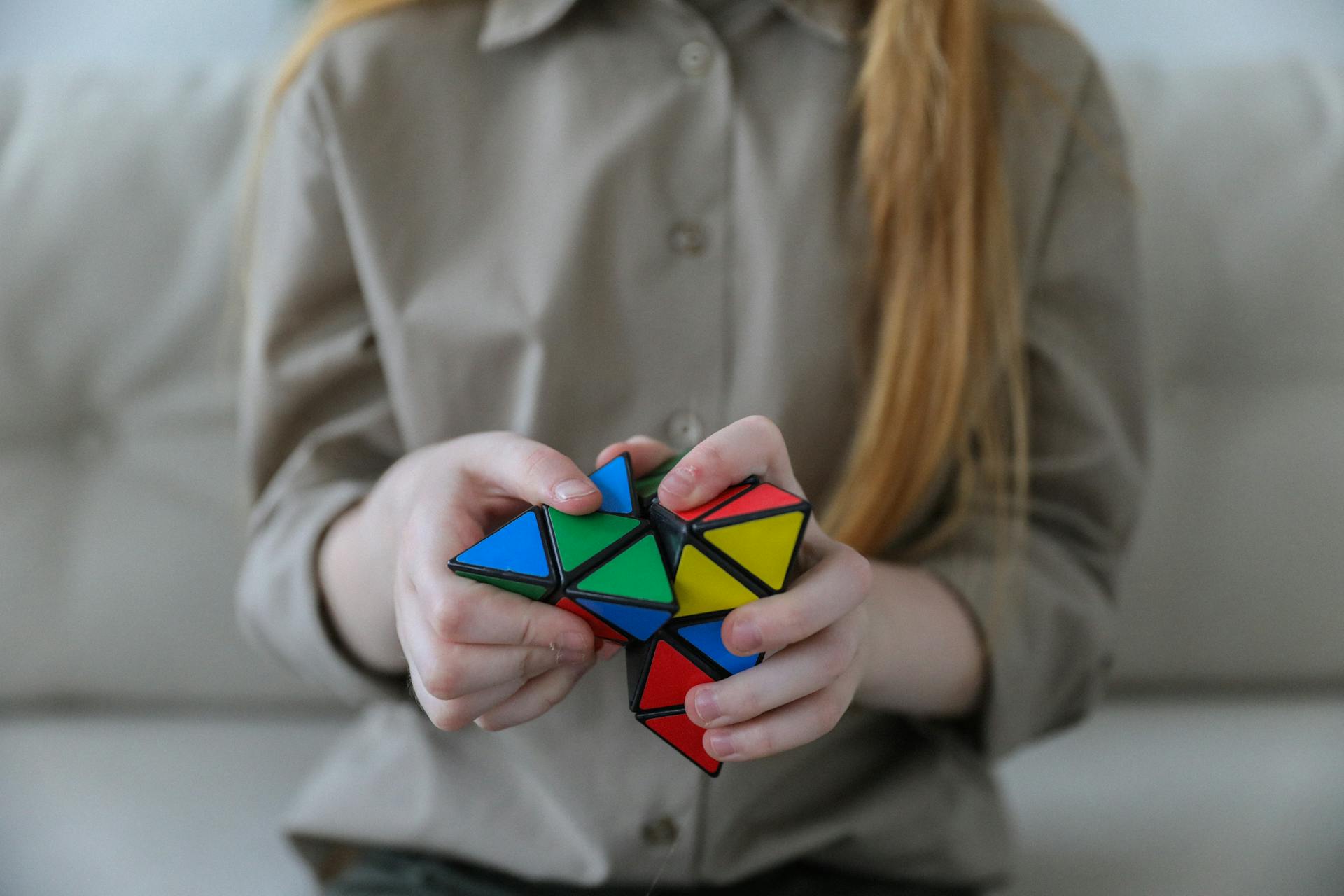 Une fille qui résout un Pyraminx | Source : Pexels