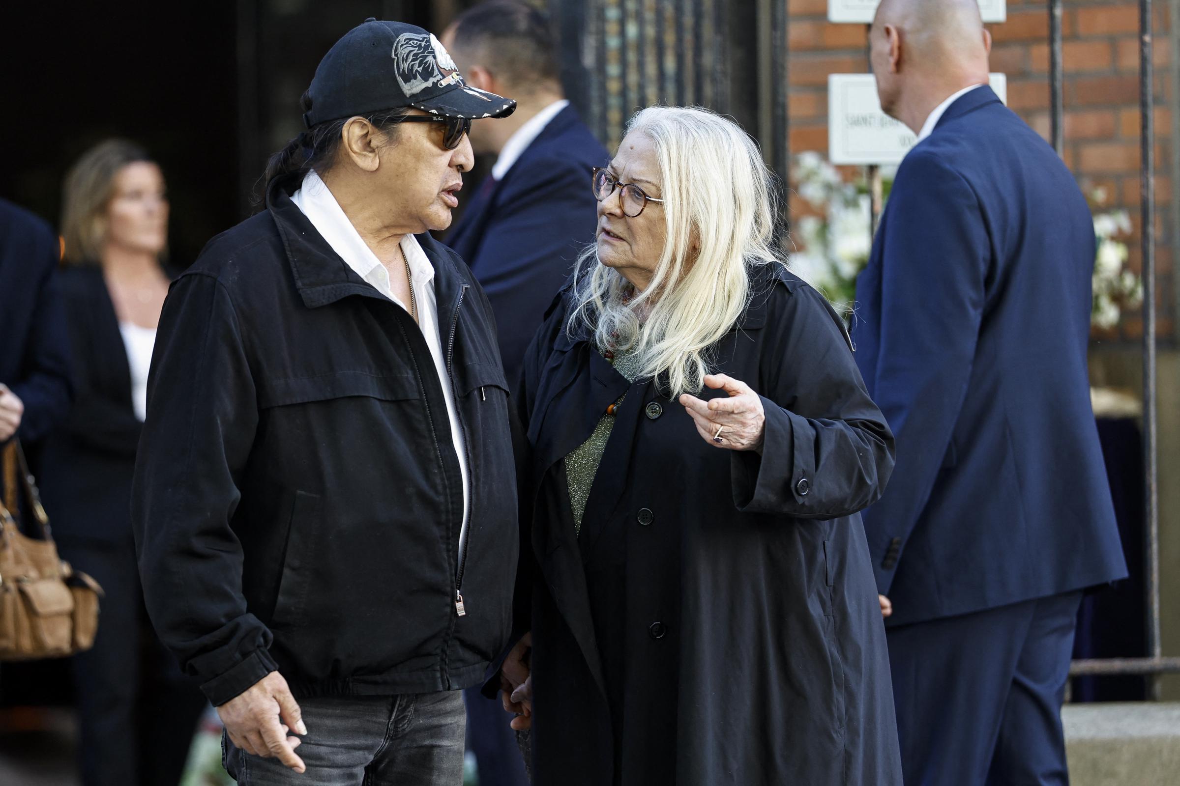 L'actrice française Josiane Balasko (à droite) s'entretient avec son mari, l'acteur américain George Aguilar, alors qu'ils quittent l'église Saint-Jean-de-Montmartre à Paris, le 24 avril 2026, après la cérémonie funéraire de l'actrice française Nadia Fares. Nadia Fares est décédée le 17 avril 2026, à l'âge de 57 ans, après avoir été retrouvée inconsciente dans une piscine à Paris et avoir passé plusieurs jours dans le coma I Source : Getty Images