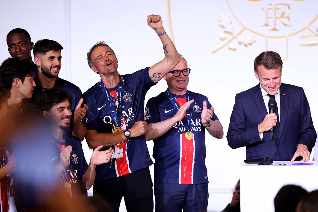 Le président français Emmanuel Macron (à droite) prononce un discours tandis que l'entraîneur espagnol du Paris Saint-Germain, Luis Enrique (3e à droite), lève le poing lors de la réception au palais présidentiel de l'Élysée à Paris, le 1er juin 2025, au lendemain de la victoire du PSG en finale de la Ligue des champions de l'UEFA 2025 contre l'Inter Milan à Munich. | Source : Getty Images