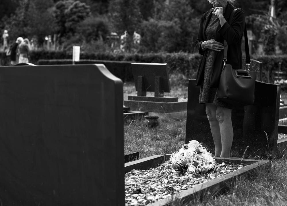 Une femme sur la tombe de son mari. | Photo: Pexels
