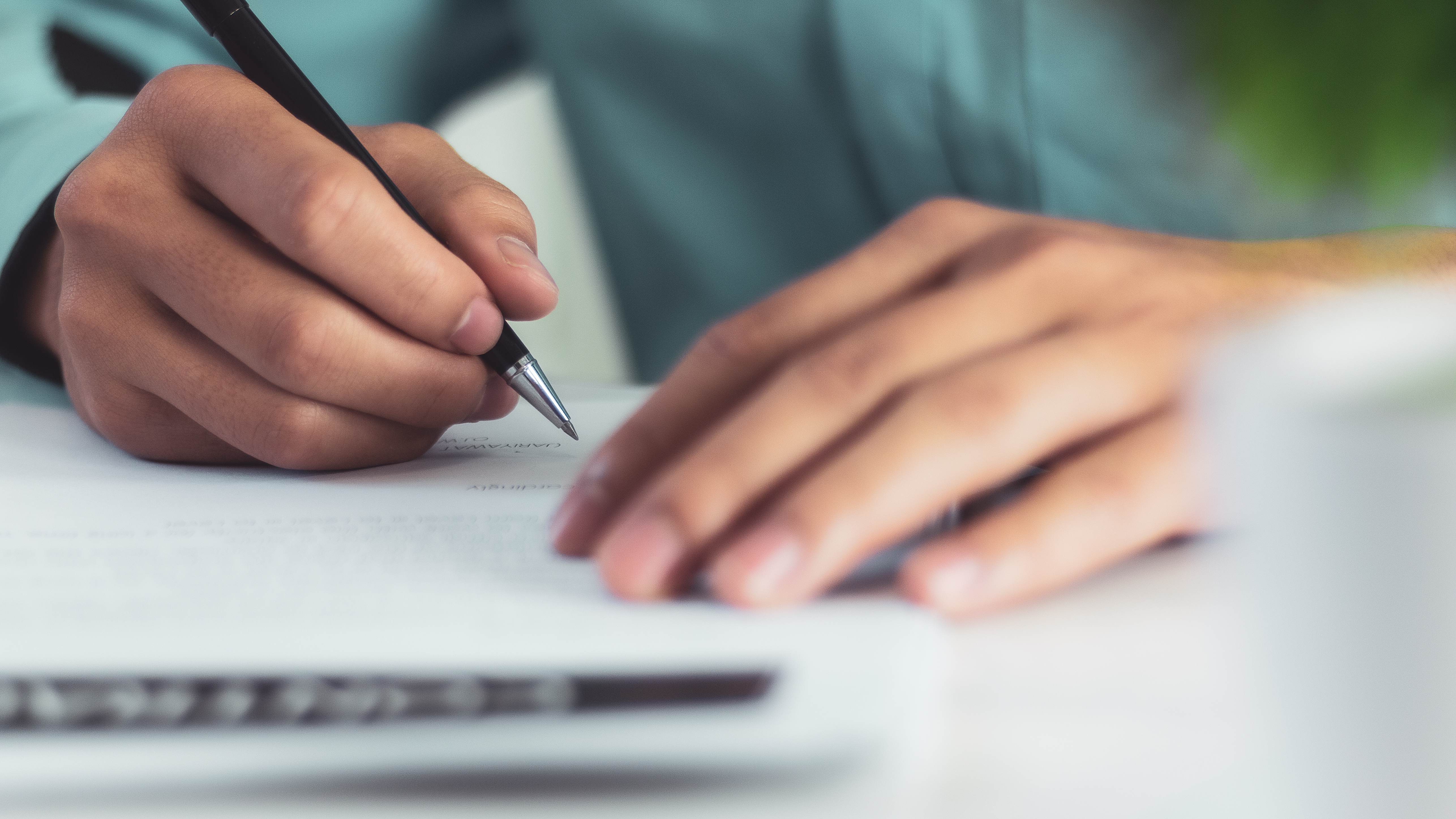 Hombre escribiendo en un papel | Fuente: Shutterstock.com