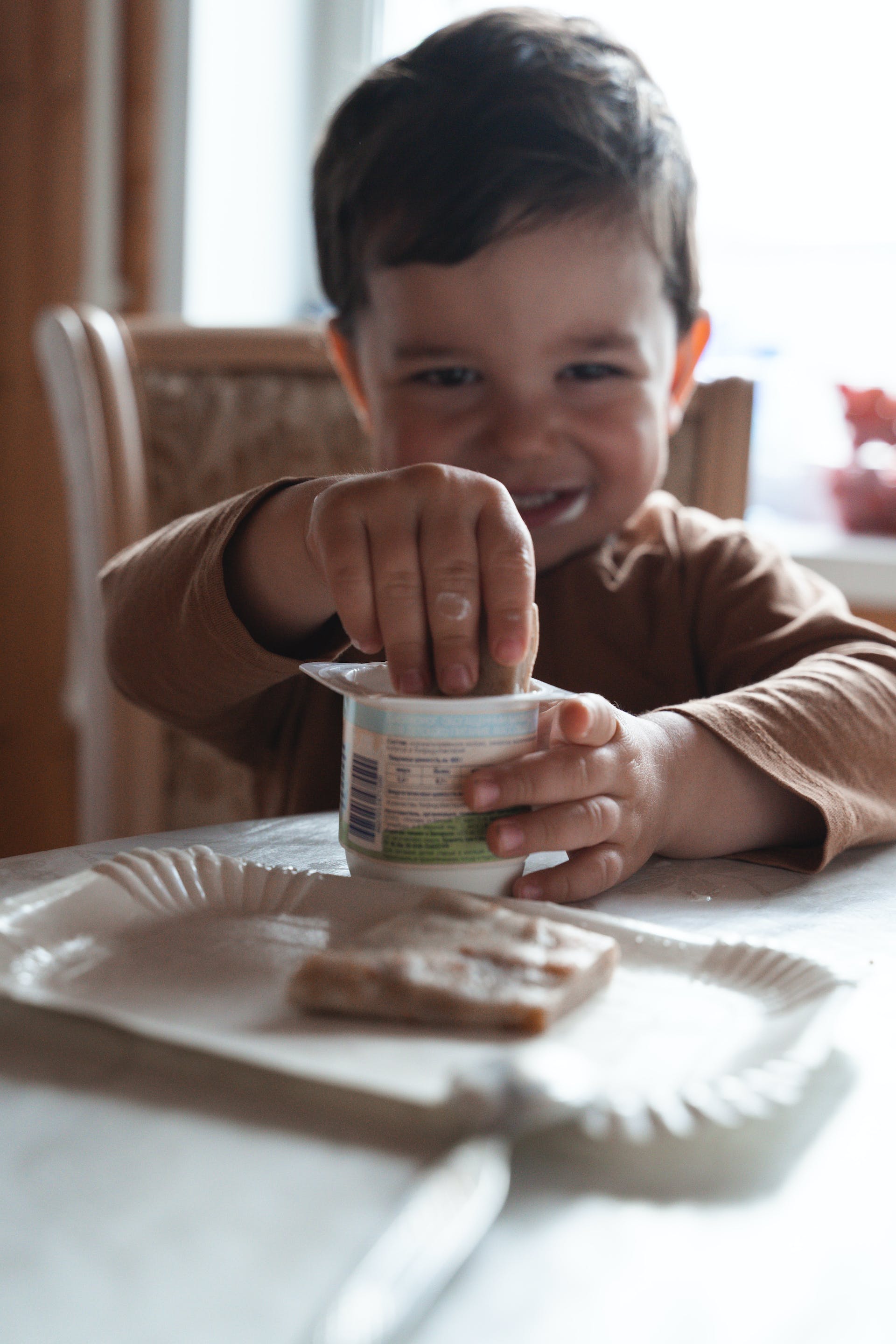 Petit garçon mangeant du yaourt | Source : Pexels