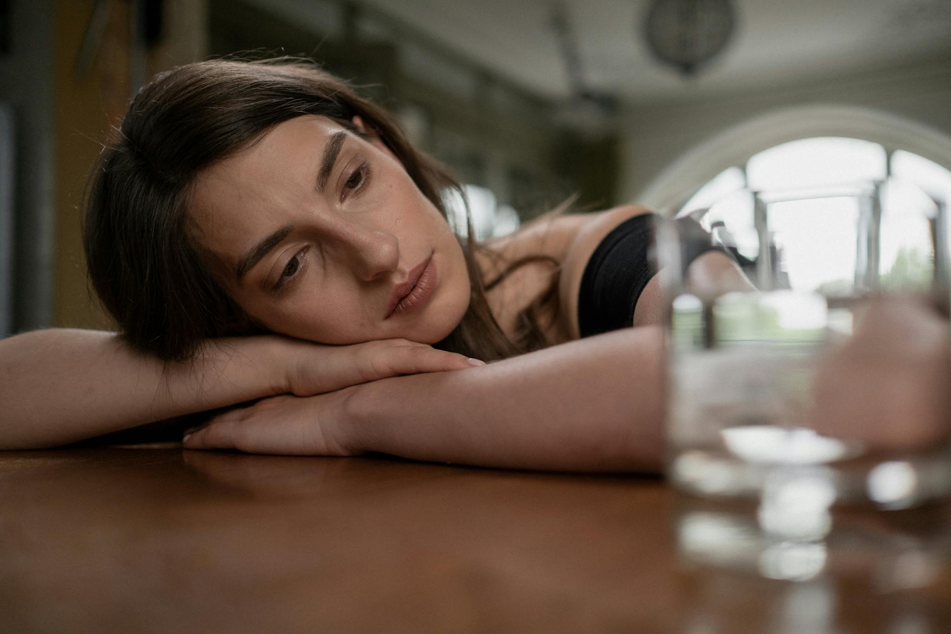 Une femme inquiète, la tête posée sur une table | Source : Pexels