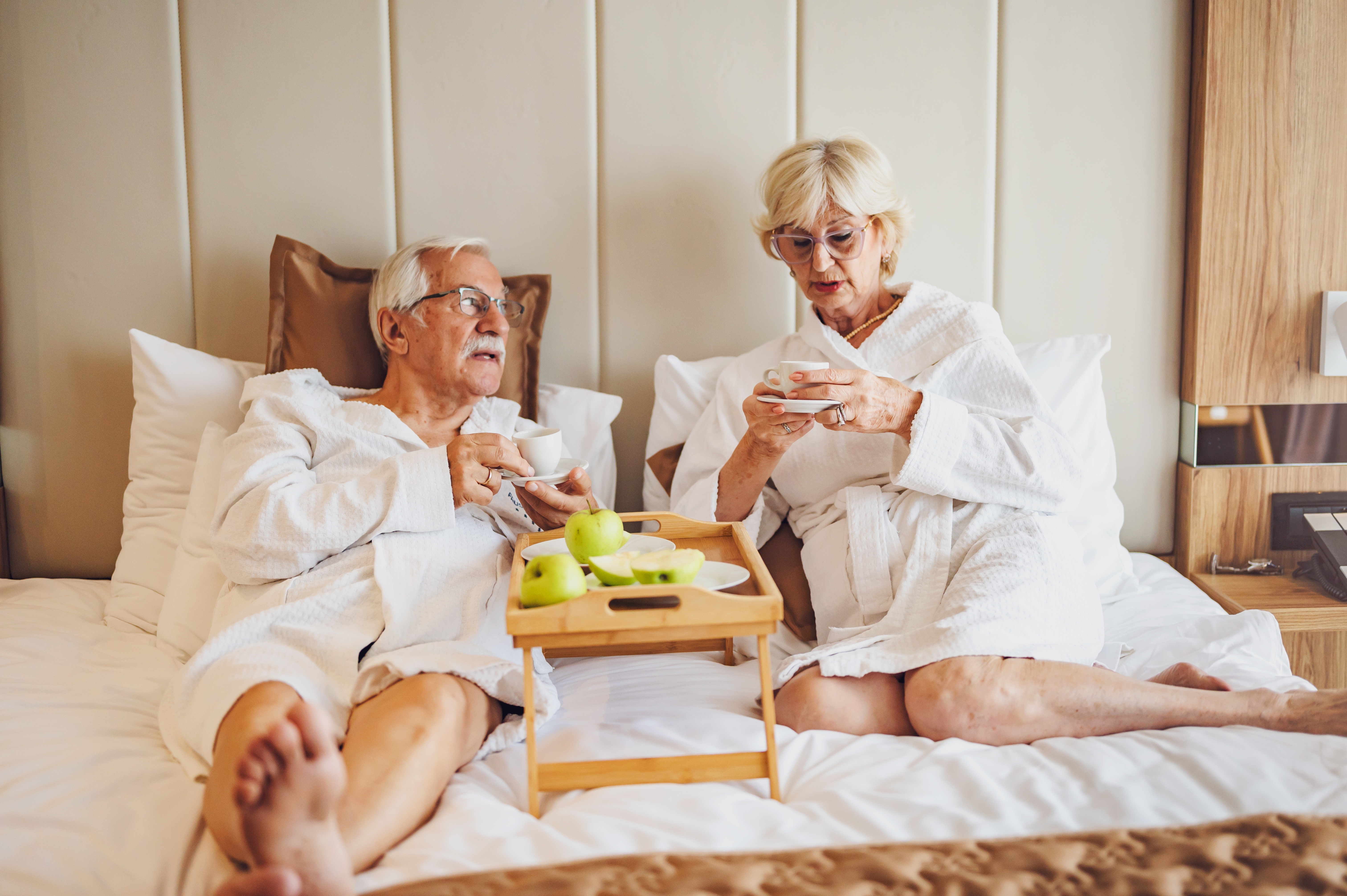Un couple de personnes âgées buvant du café dans une chambre d'hôtel | Source : Shutterstock