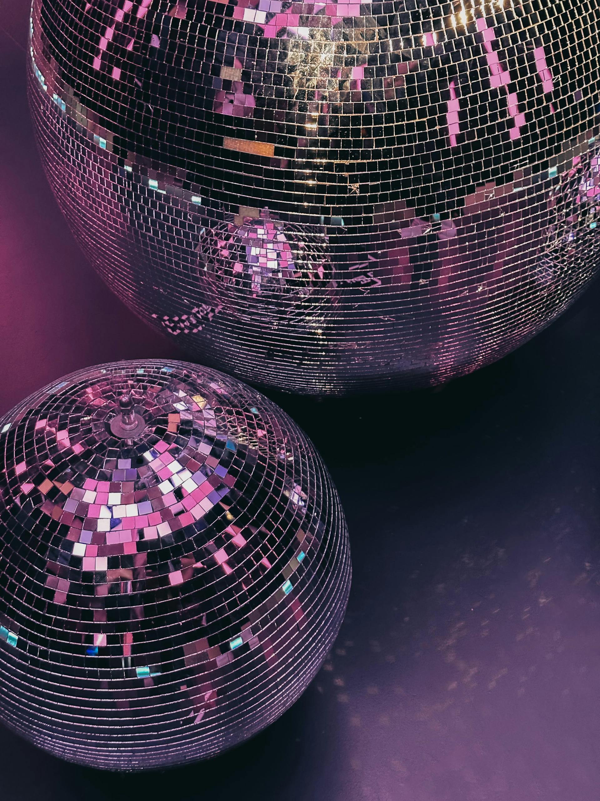 Gros plan sur des boules disco sous un éclairage violet | Source : Pexels